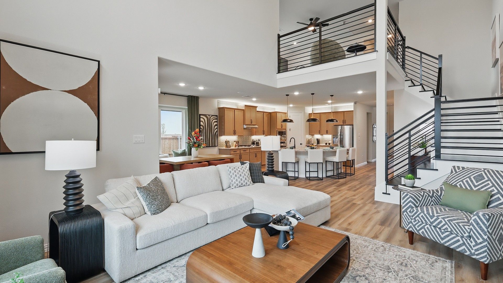 Elegant open-plan living area with airy loft, sleek iron staircase, and premium wood finishes in Westridge.
