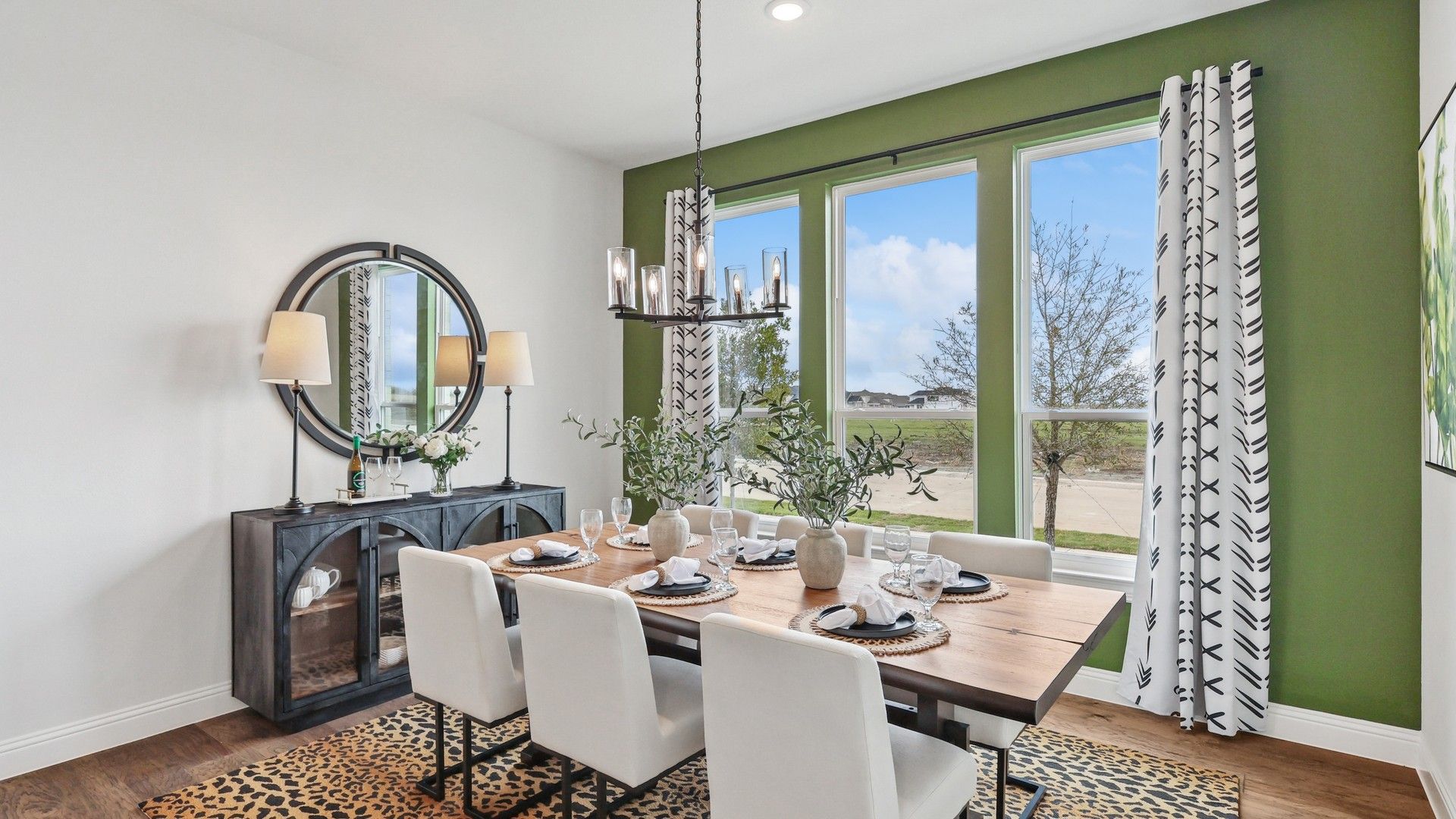 Experience refined elegance with a wood table, plush seating, and expansive windows in Green Meadows.