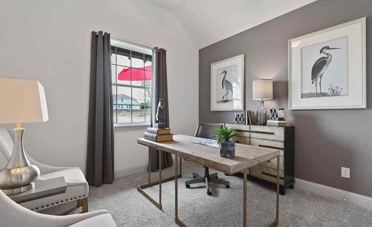 Luxurious home office in Thompson Farms features a sleek wood desk and elegant heron artwork.