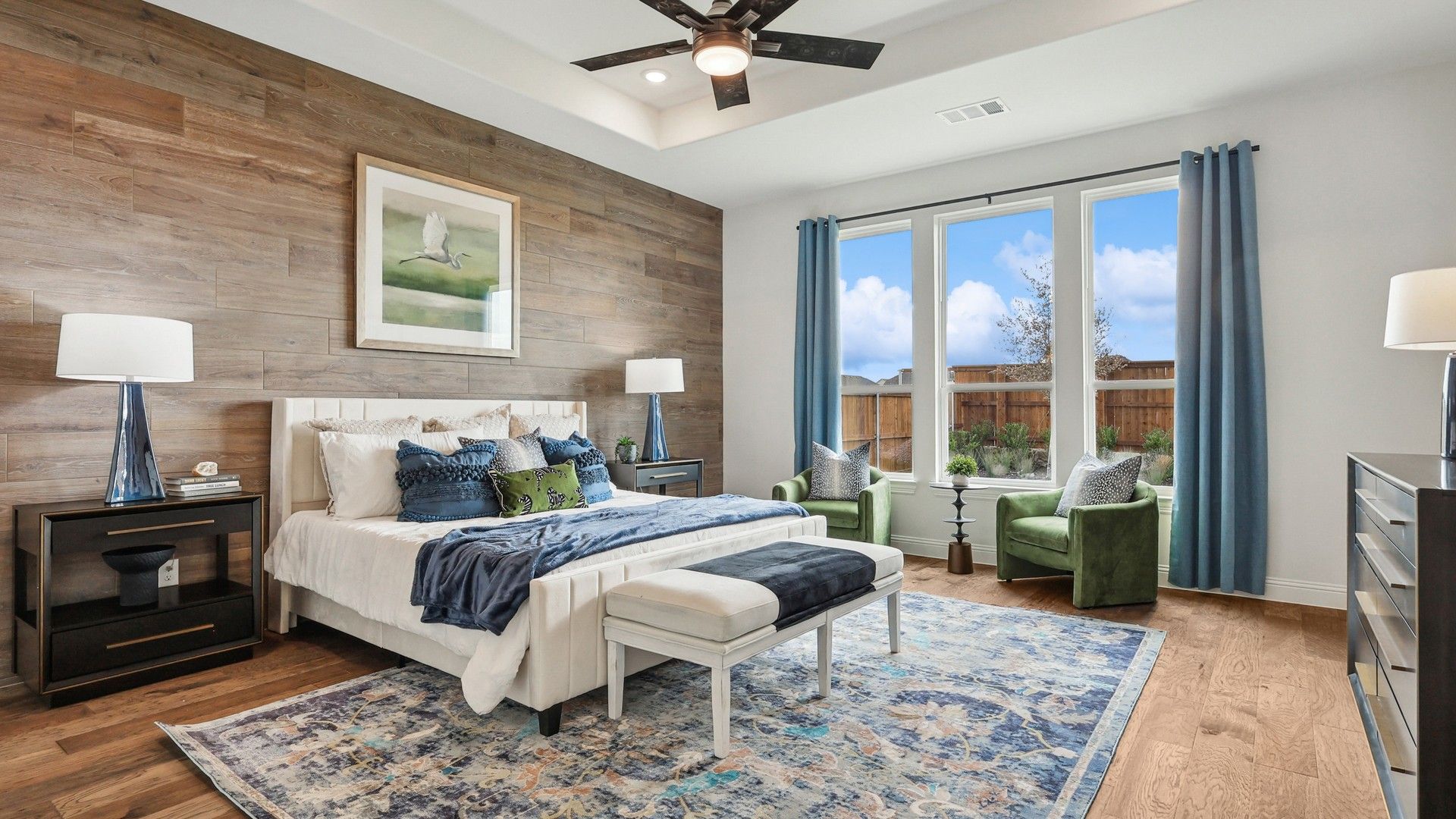 Experience sophistication with a wood accent wall, plush seating, and expansive windows. Green Meadows elegance.