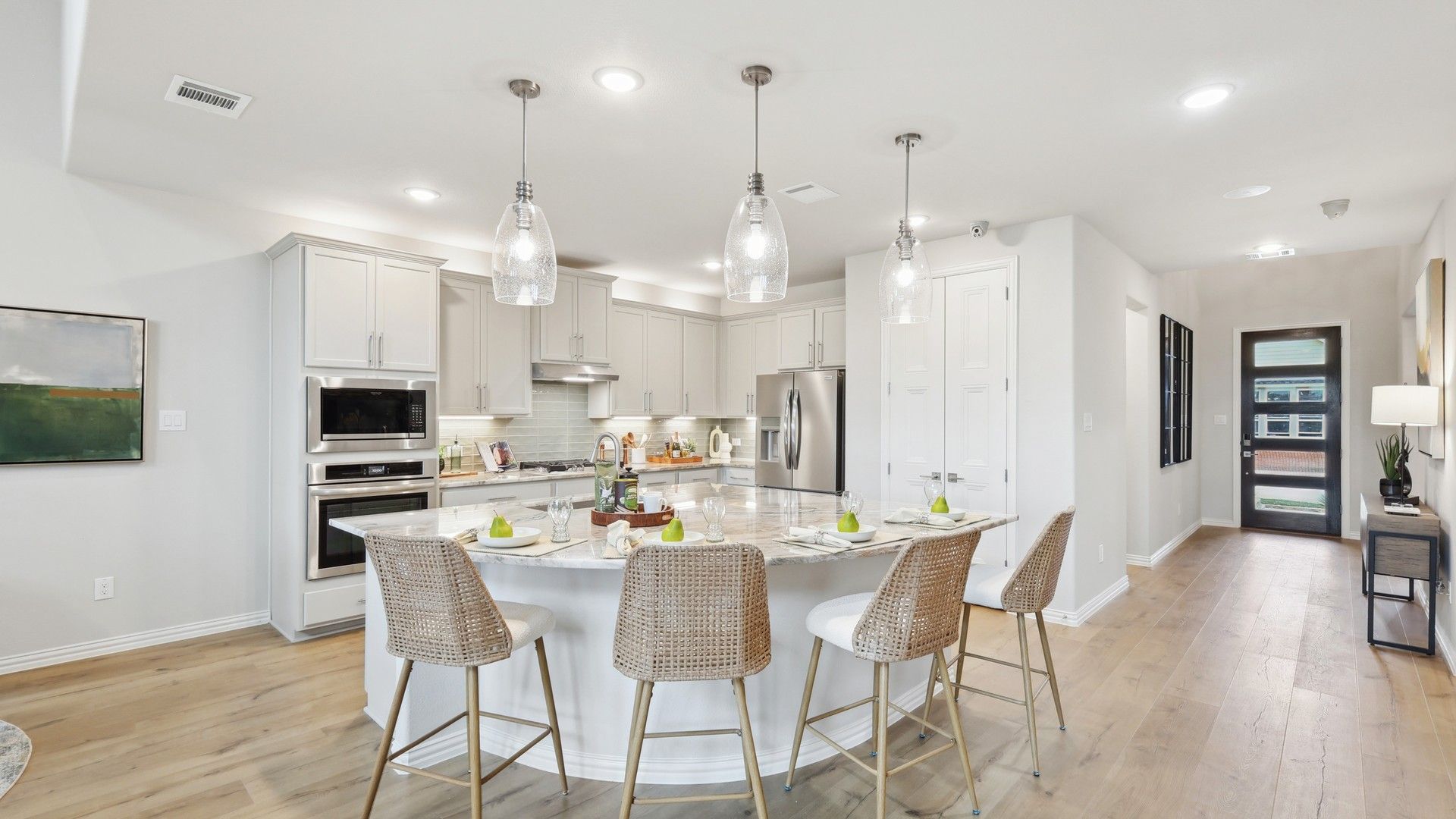 Elegant marble island complements woven barstools in luxurious Wildflower Ranch kitchen.