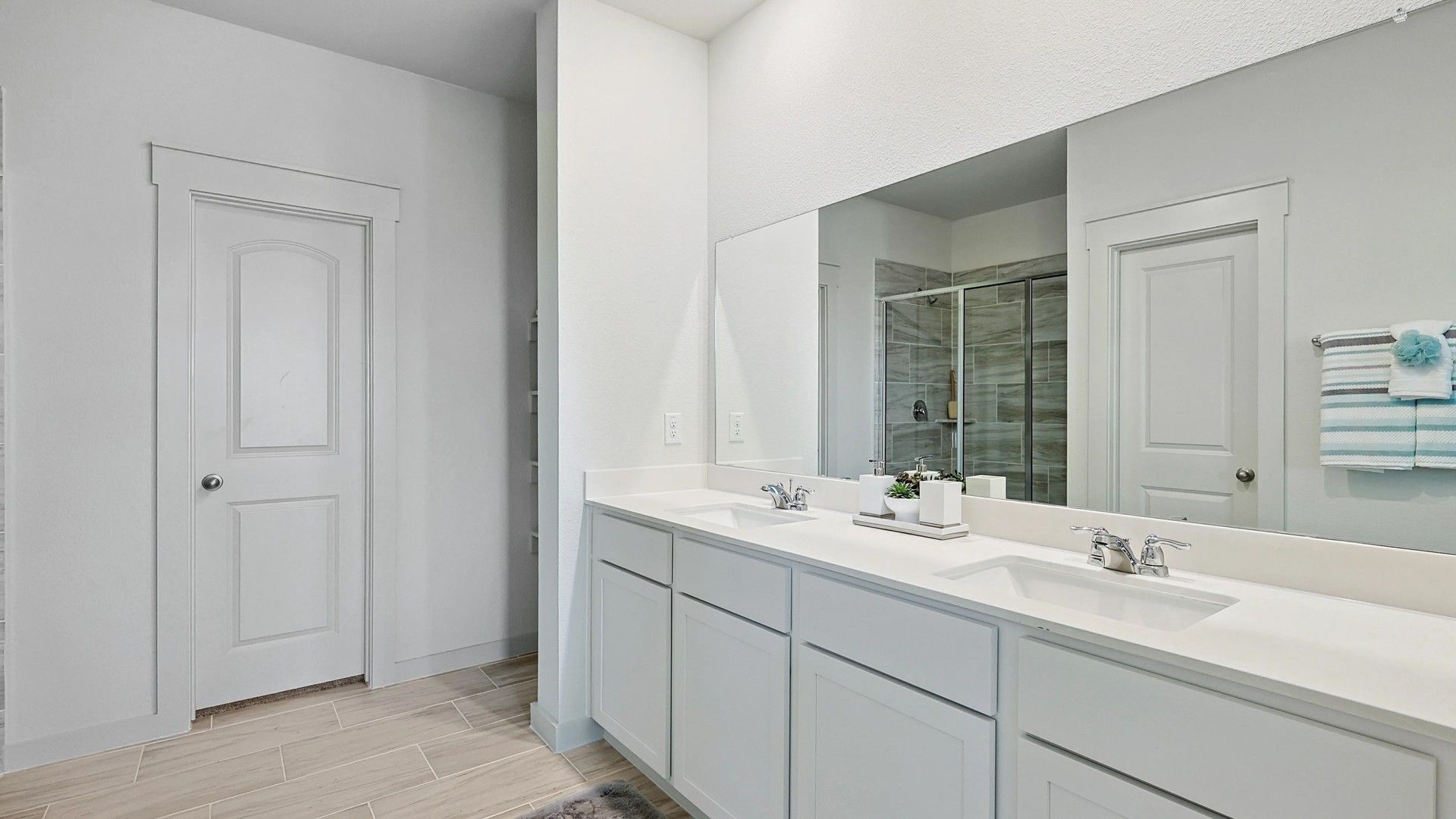 Dual sink vanity and sleek glass shower create a luxurious bathroom retreat in Patriot Estates.