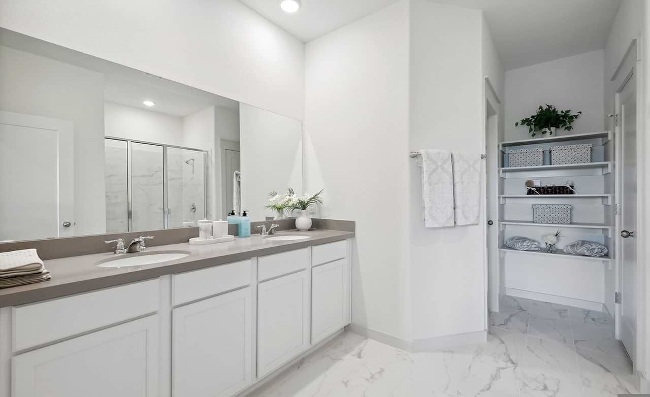 Experience luxury with marble floors and sleek double vanities in Walden Pond's upscale community bathroom.