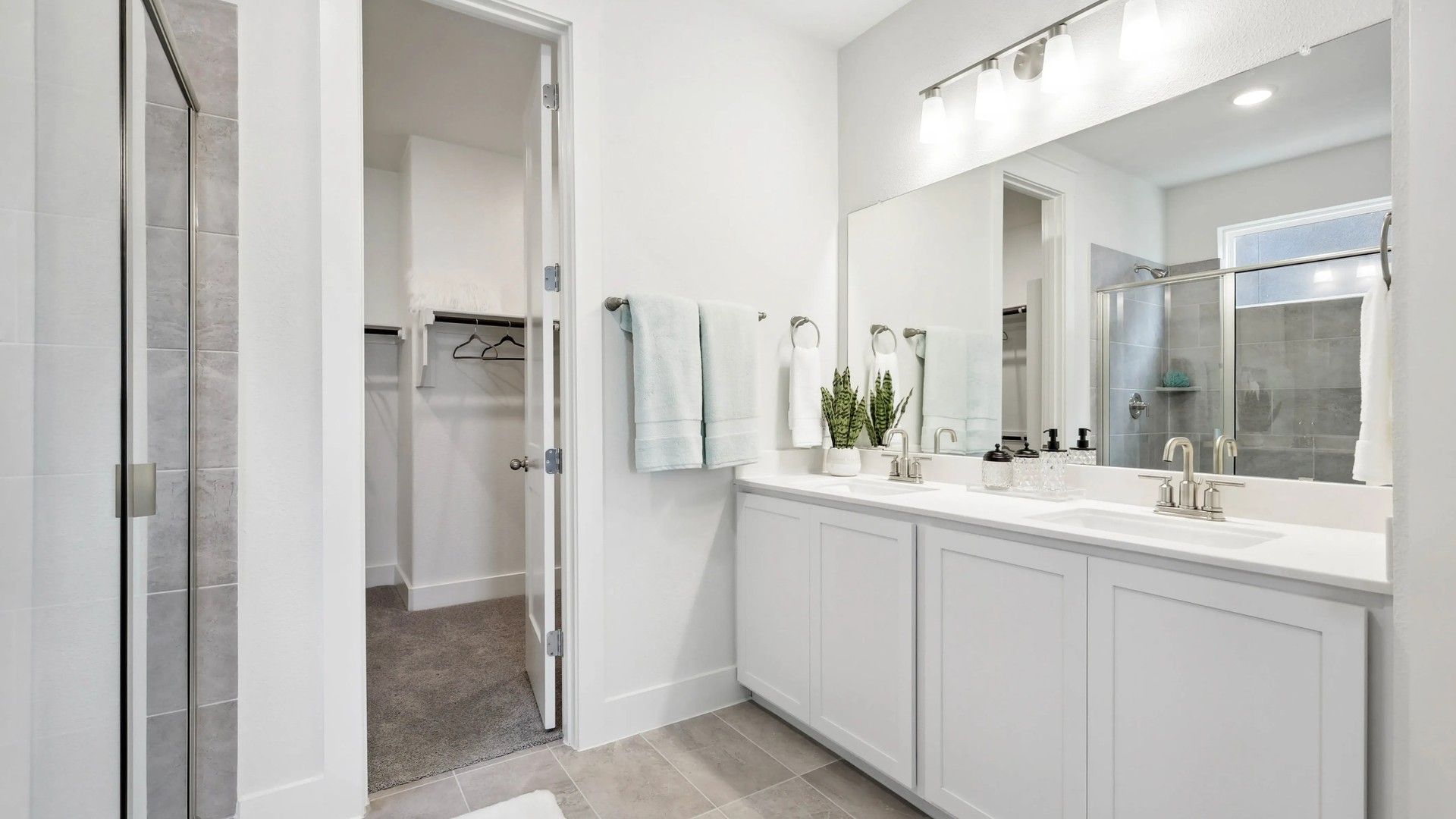 Luxurious double vanity and expansive glass shower create an elegant retreat in Collin Creek.