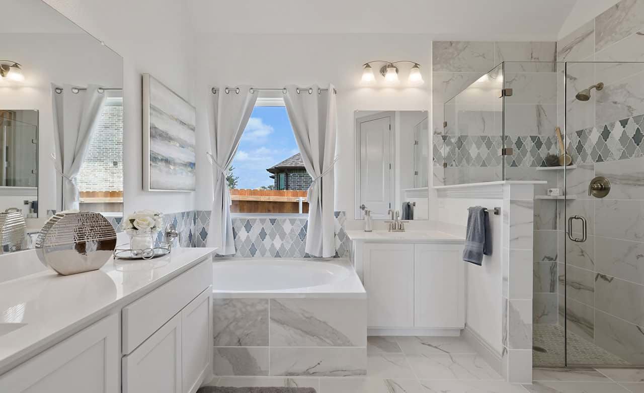 Marble tiles and a seamless glass shower define this opulent bathroom in Thompson Farms.