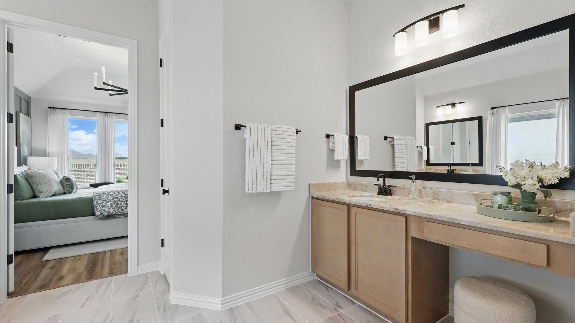 Marble countertops and expansive mirror enhance this sophisticated bathroom in Westridge.