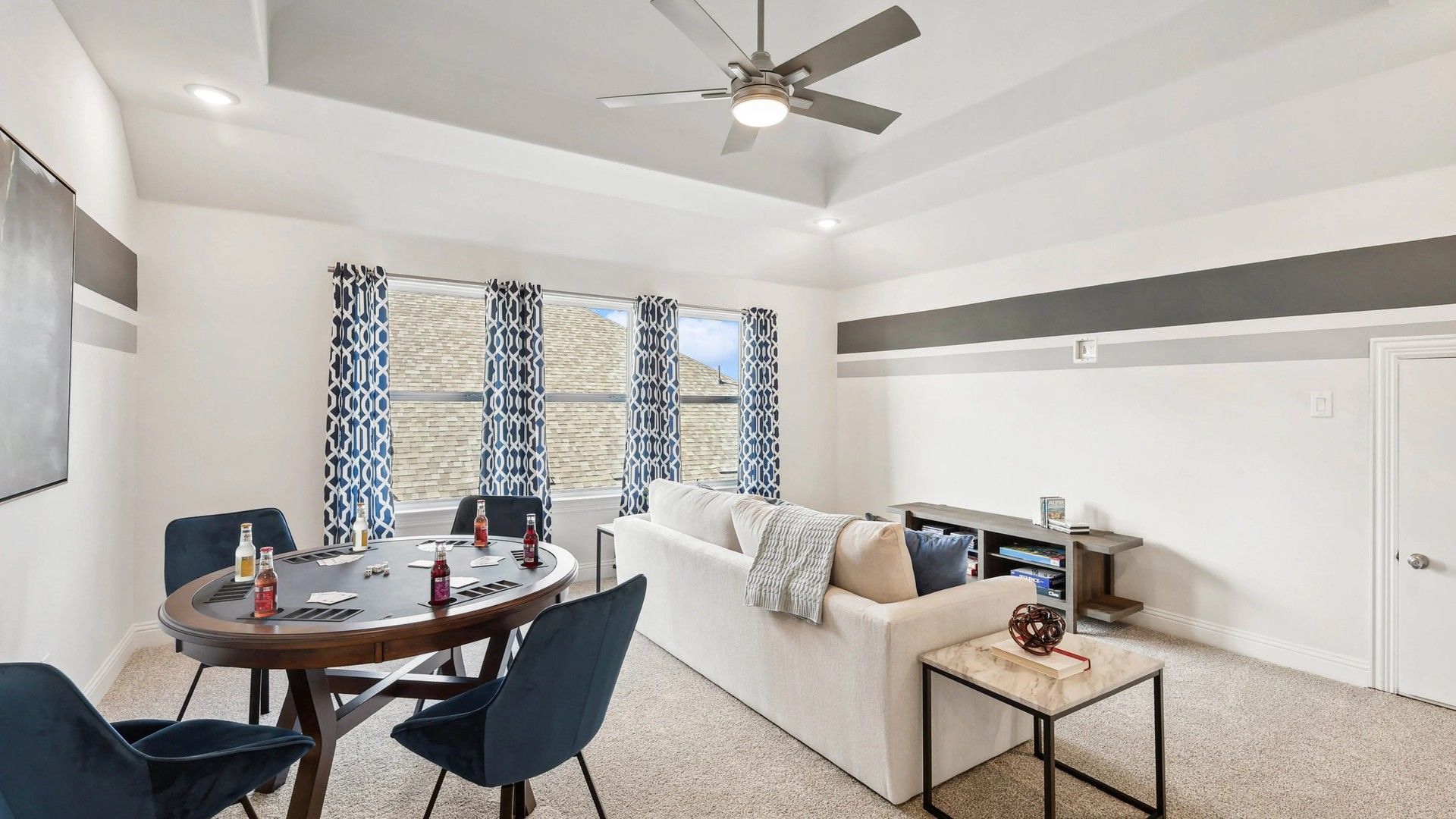 Ridge Crossing's sophisticated living room boasts a stylish ceiling fan and chic geometric curtains.