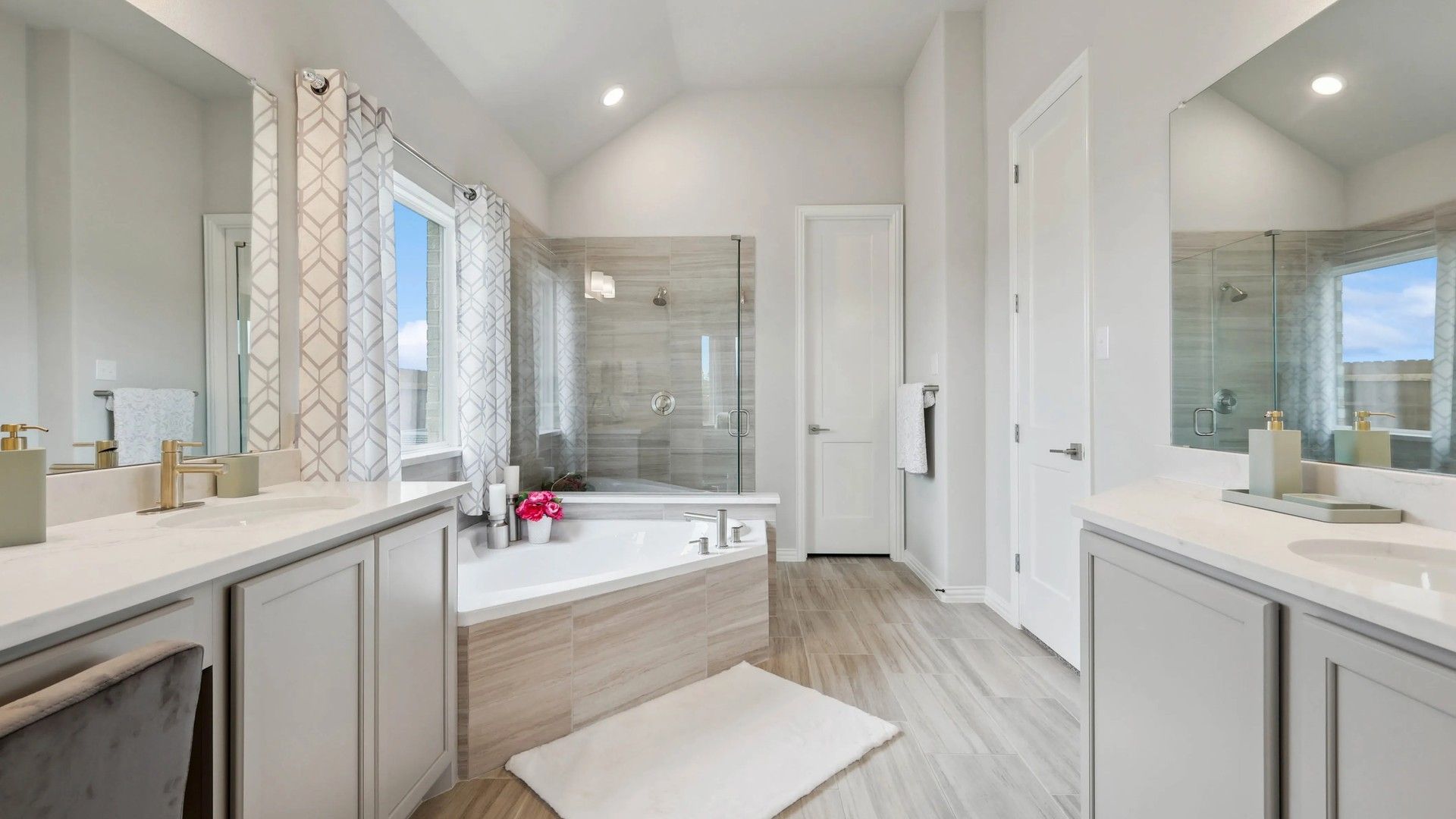 Elegant bathroom with marble floors, glass shower, and stylish vanity in upscale Hulen Trails community.