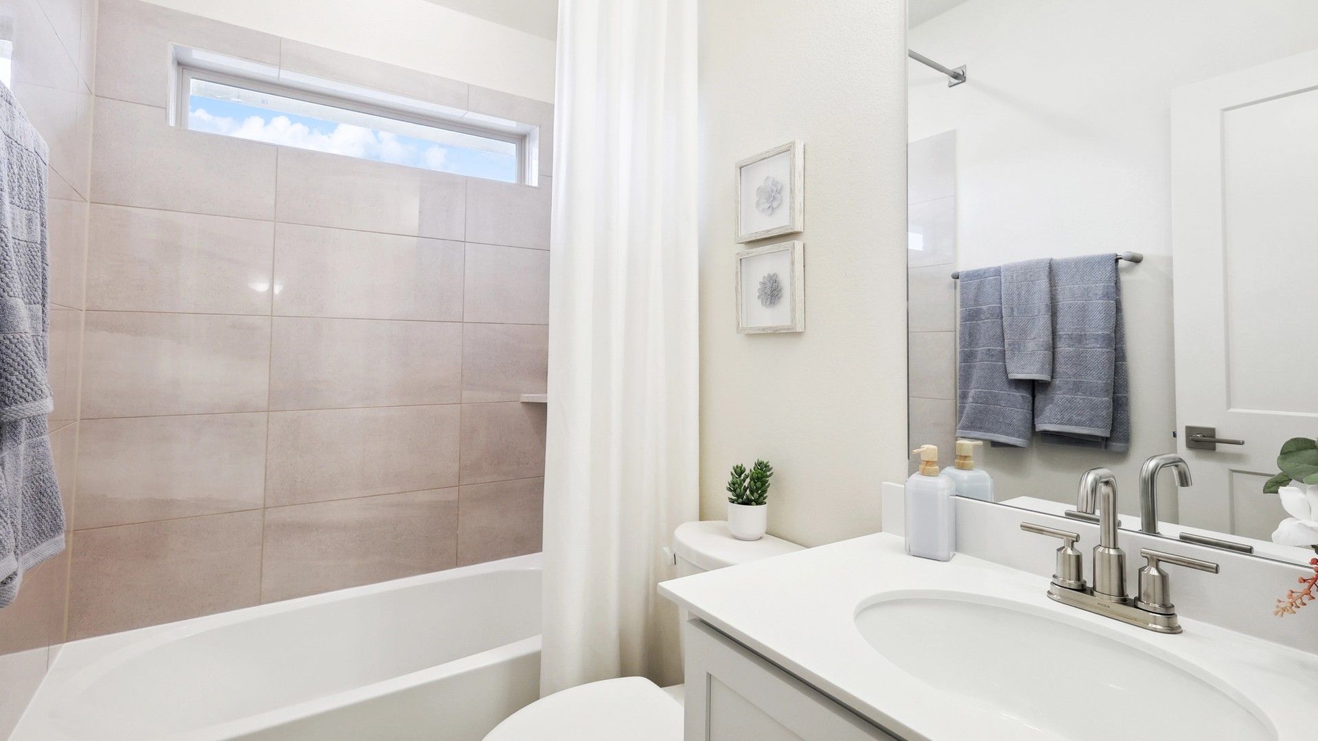 Experience refined elegance with minimalist decor and soft beige tiles in The Oaks’ bathroom.