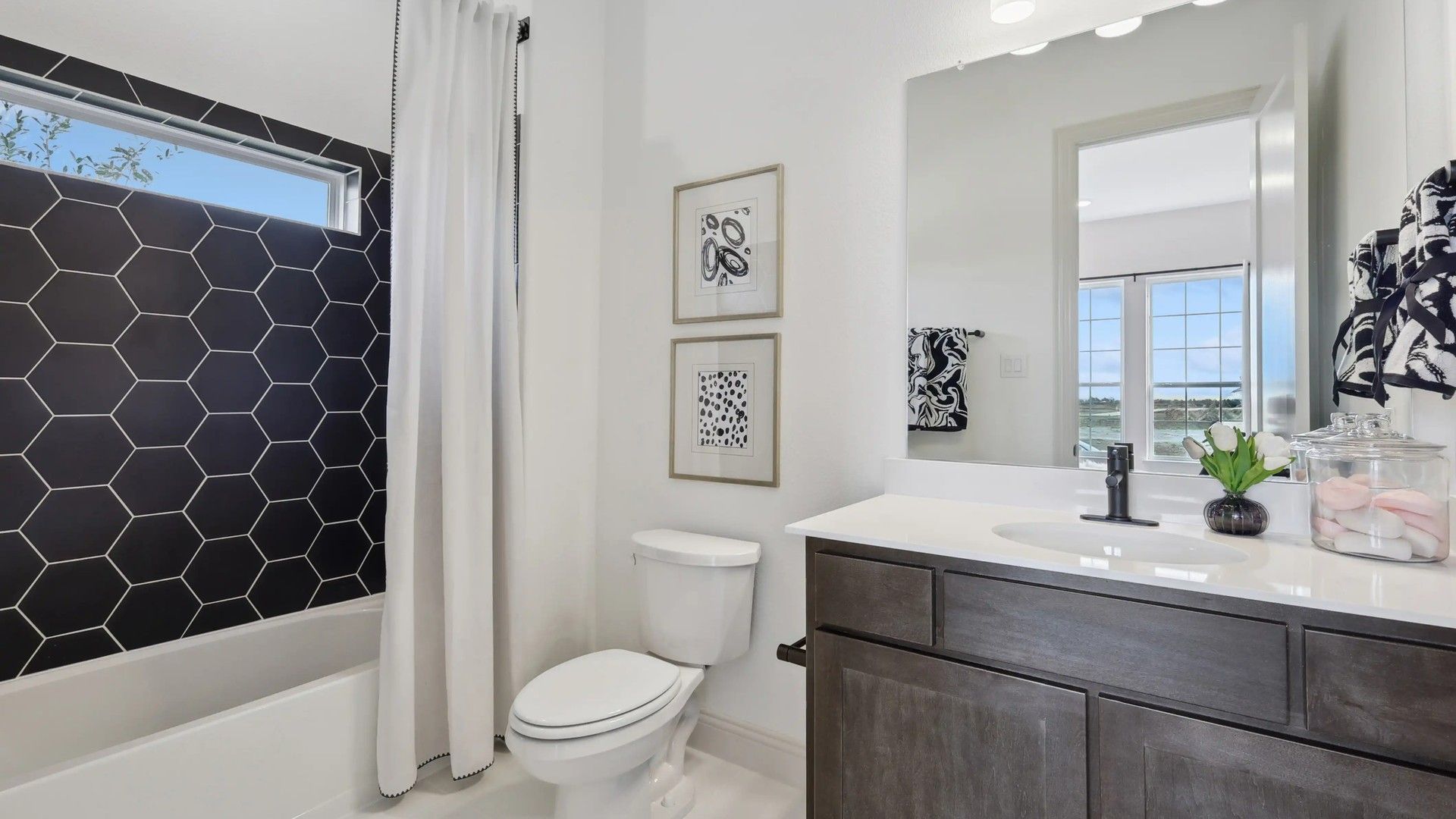 Elegant bathroom with bold hexagonal tile and stylish vanity. Expansive window views enhance Westside Preserve living.