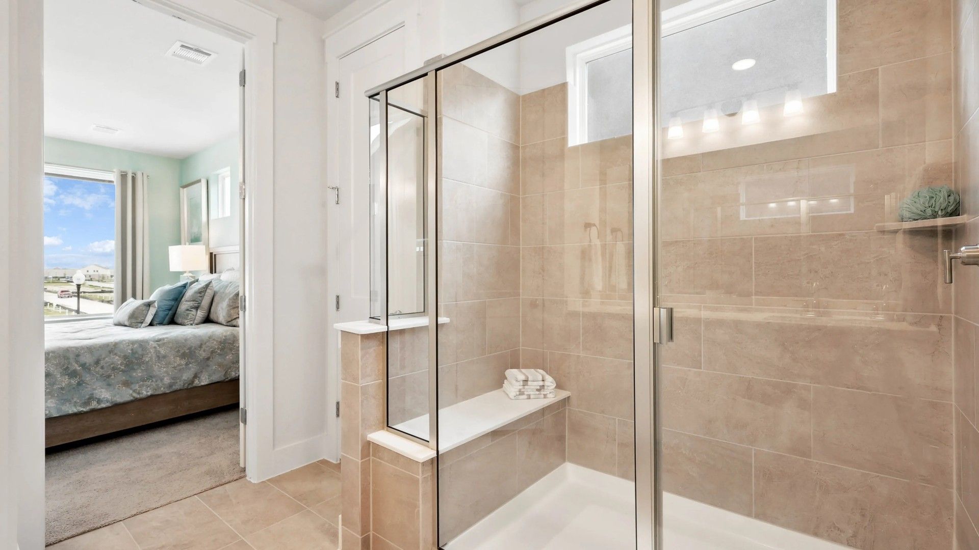Experience chic design with a glass-enclosed shower and premium beige tiles in Collin Creek's exquisite homes.