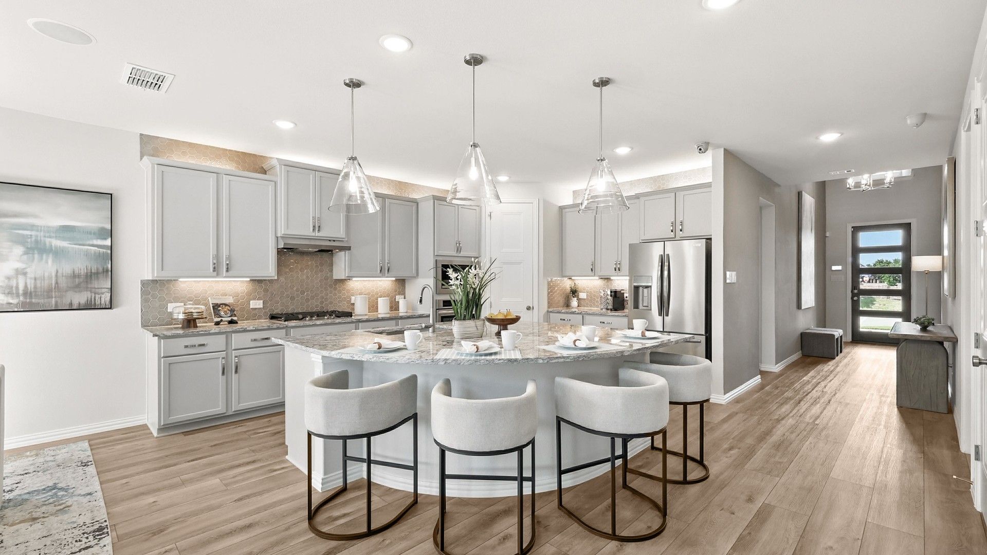Marvel at the marble island, chic cabinetry, and exquisite pendant lighting in Green Oaks Preserve.