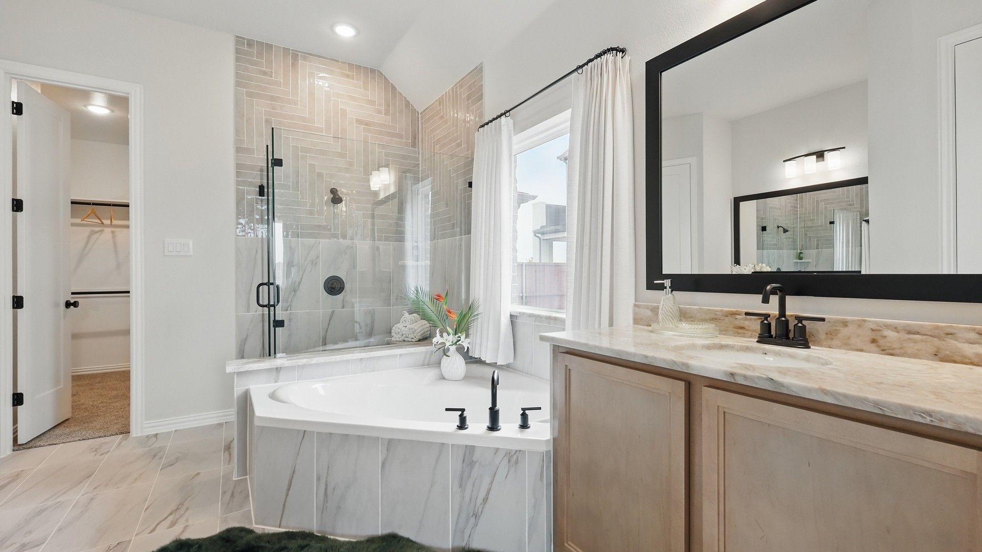 Indulge in a spacious marble bathroom with sleek glass shower and custom cabinetry in Westridge.
