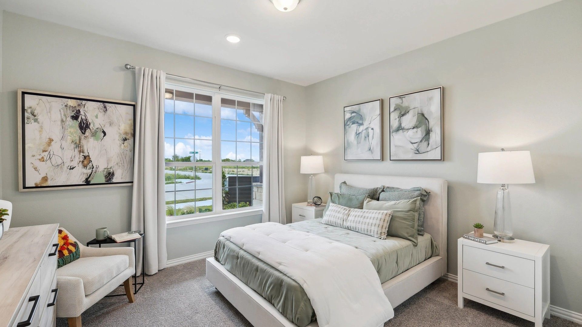 Luxurious bedroom features expansive window, plush textiles, and fine art. Hulen Trails location.