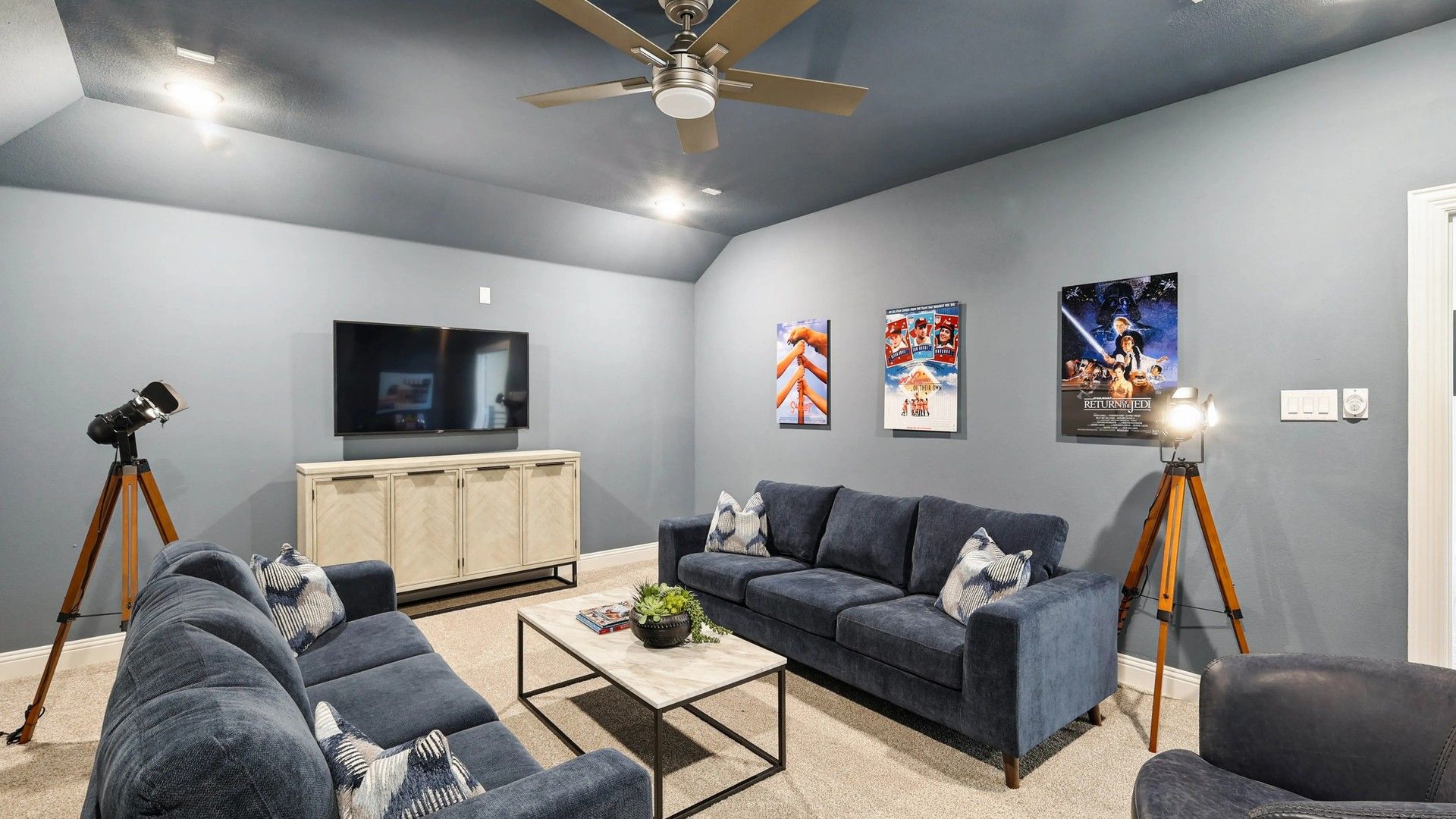 Experience plush navy seating and sleek contemporary lighting in this Ridge Crossing media room.