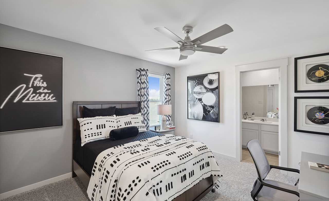 Luxurious ensuite in monochrome hues with plush bedding, elegant fan, and contemporary decor, Walden Pond.