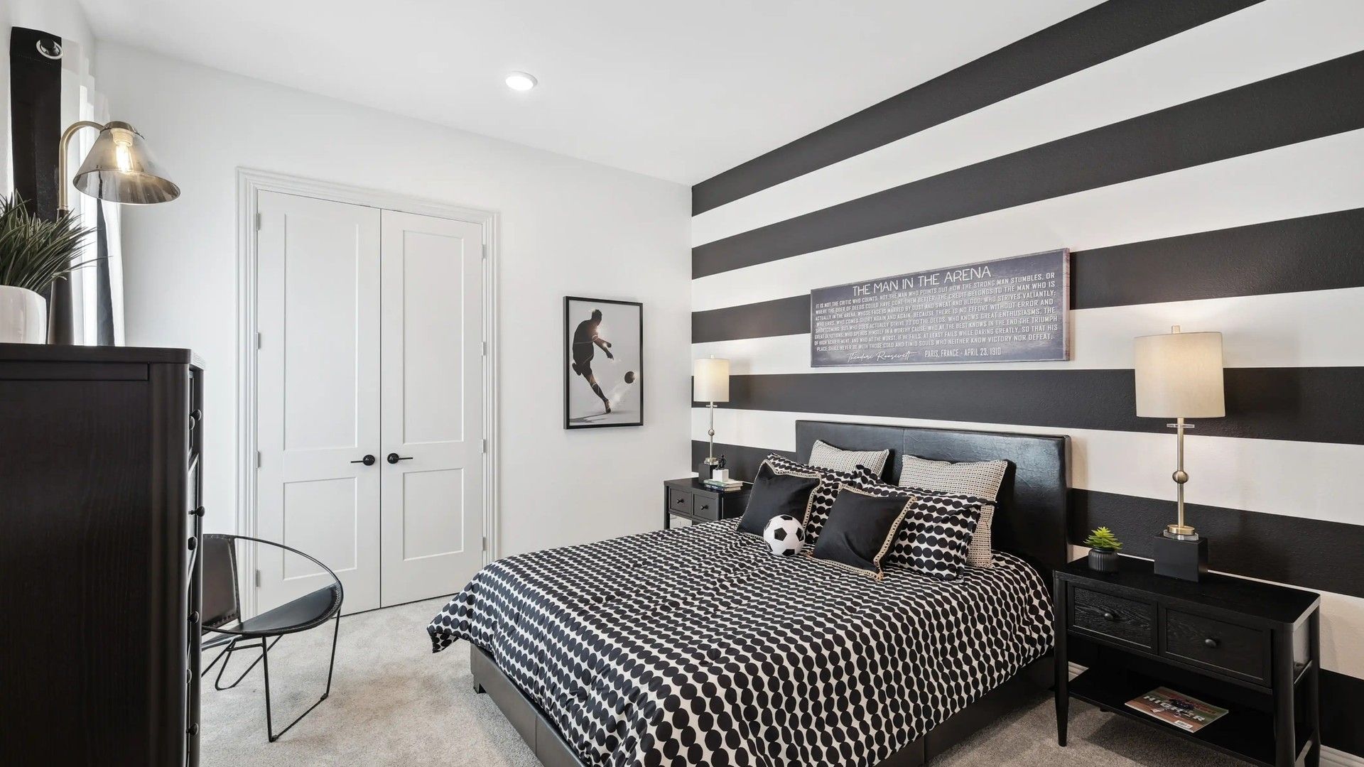 Elegant bedroom features striking striped walls, plush carpet, and sleek furniture in Westside Preserve.