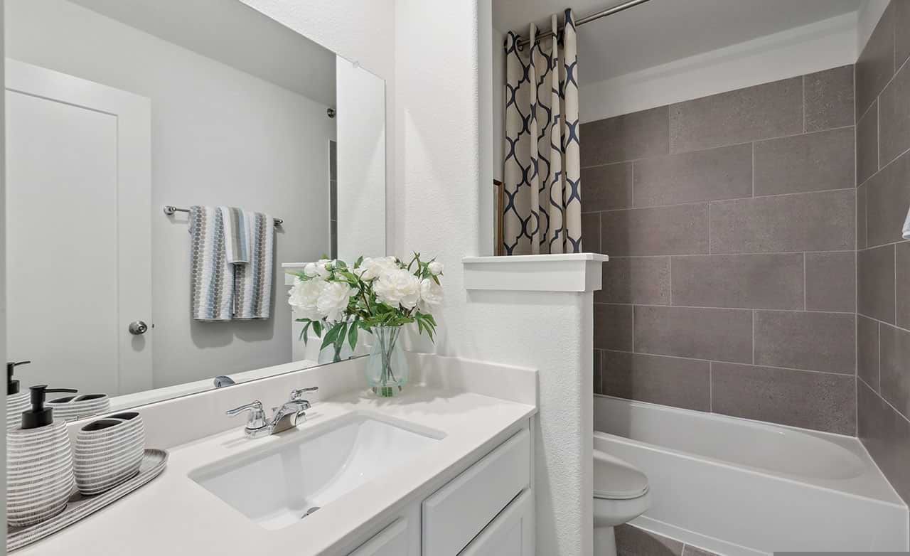 Luxurious bathroom with sleek vanity, gray tiles, and refined accents, nestled in Walden Pond.
