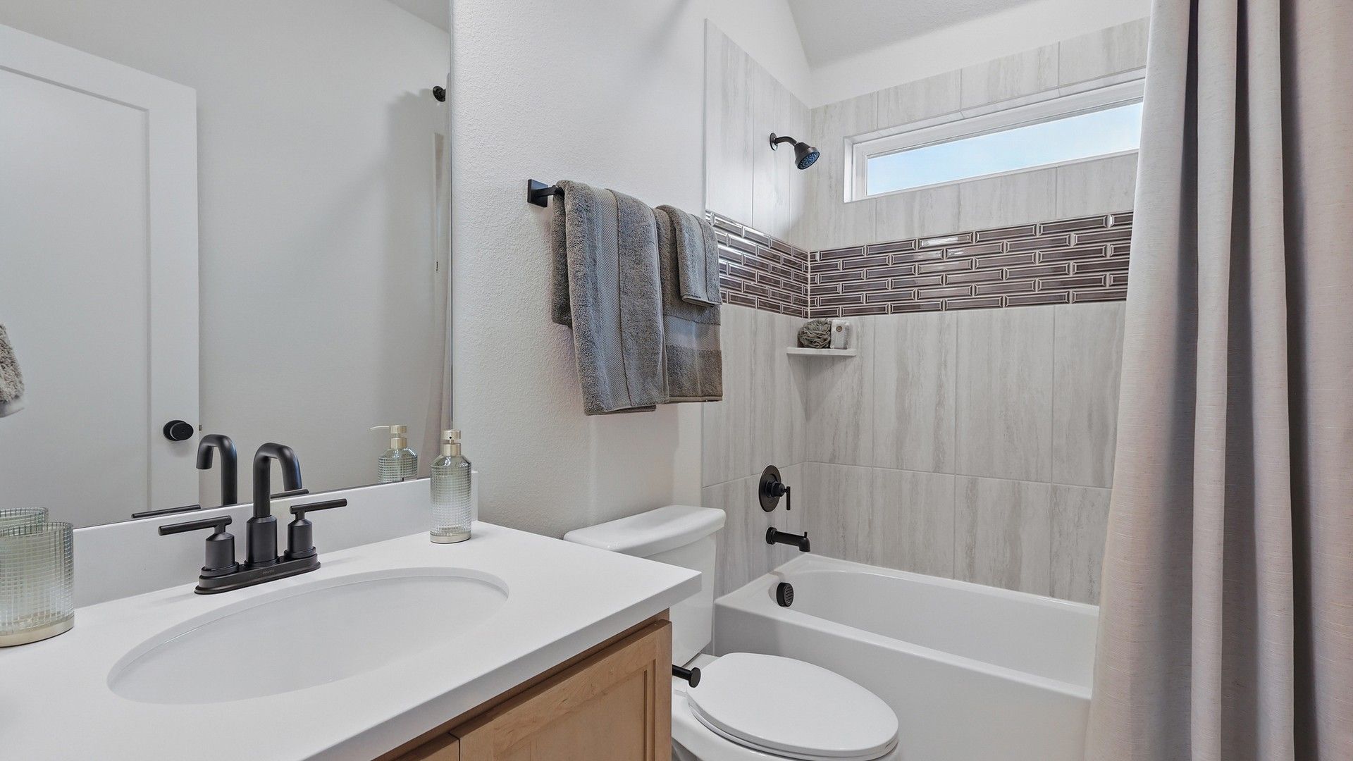 Marble tiles accentuate luxury, complemented by sleek fixtures in Westridge's refined bathroom design.