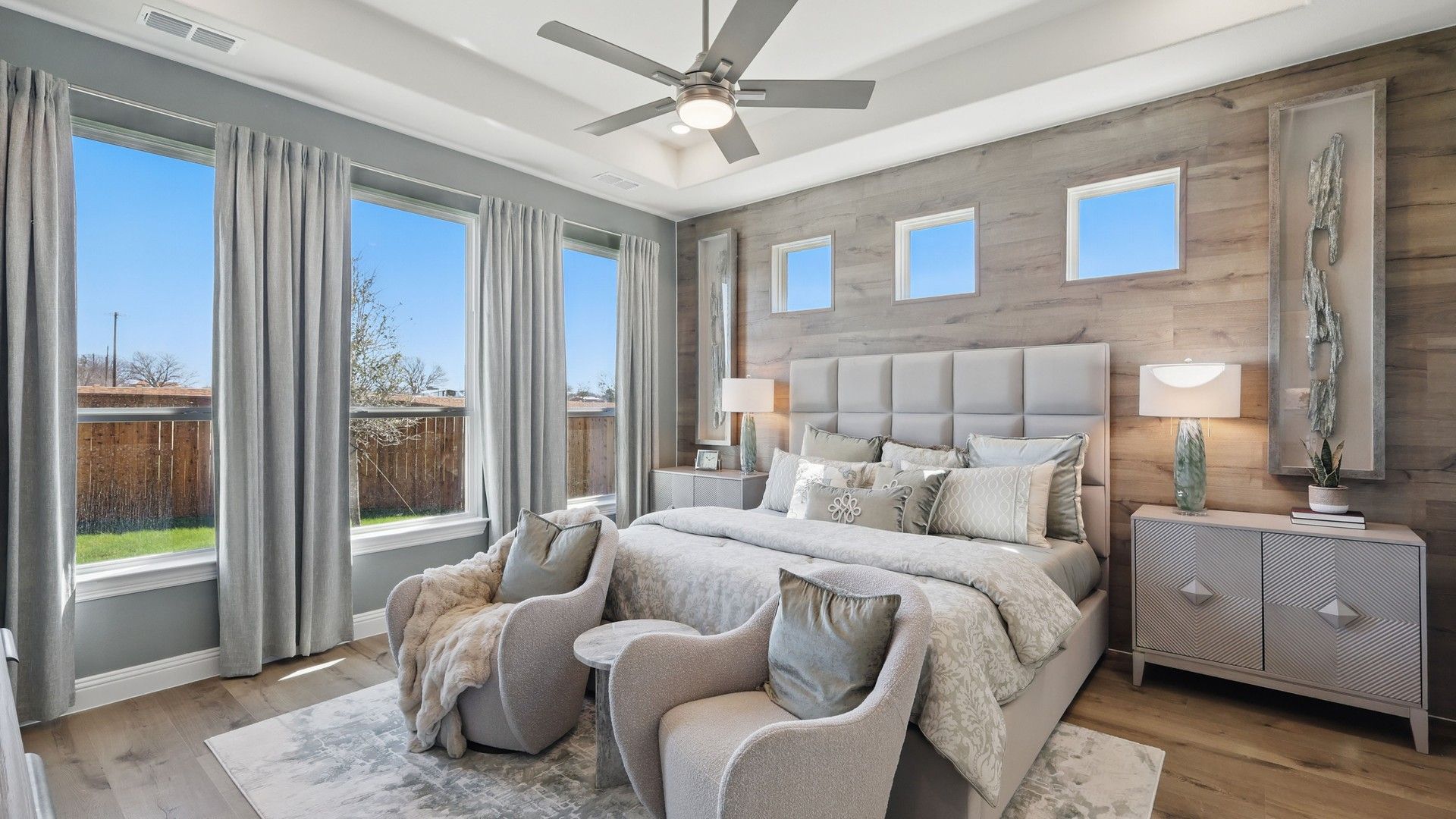 Experience luxury with wood accent walls, plush bedding, and expansive windows at Rio Vista Kelly Ranch.