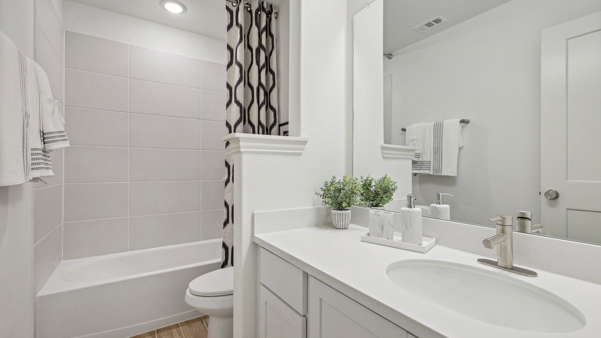 Immerse in luxury with a sleek white vanity, elegant chrome fixtures, and exquisite stone tile in Bel Air Village.