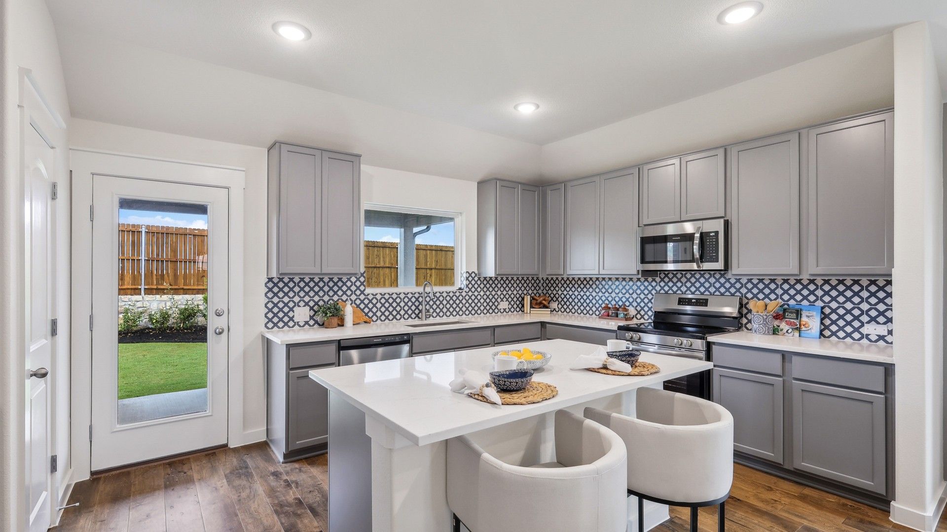 Experience luxury with custom cabinetry, chic patterned backsplash, and rich hardwood floors in Churchill.