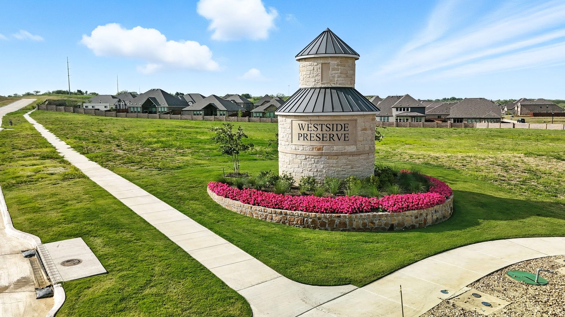 Elegantly crafted stone monument with vibrant floral accents at Westside Preserve enhances modern living.