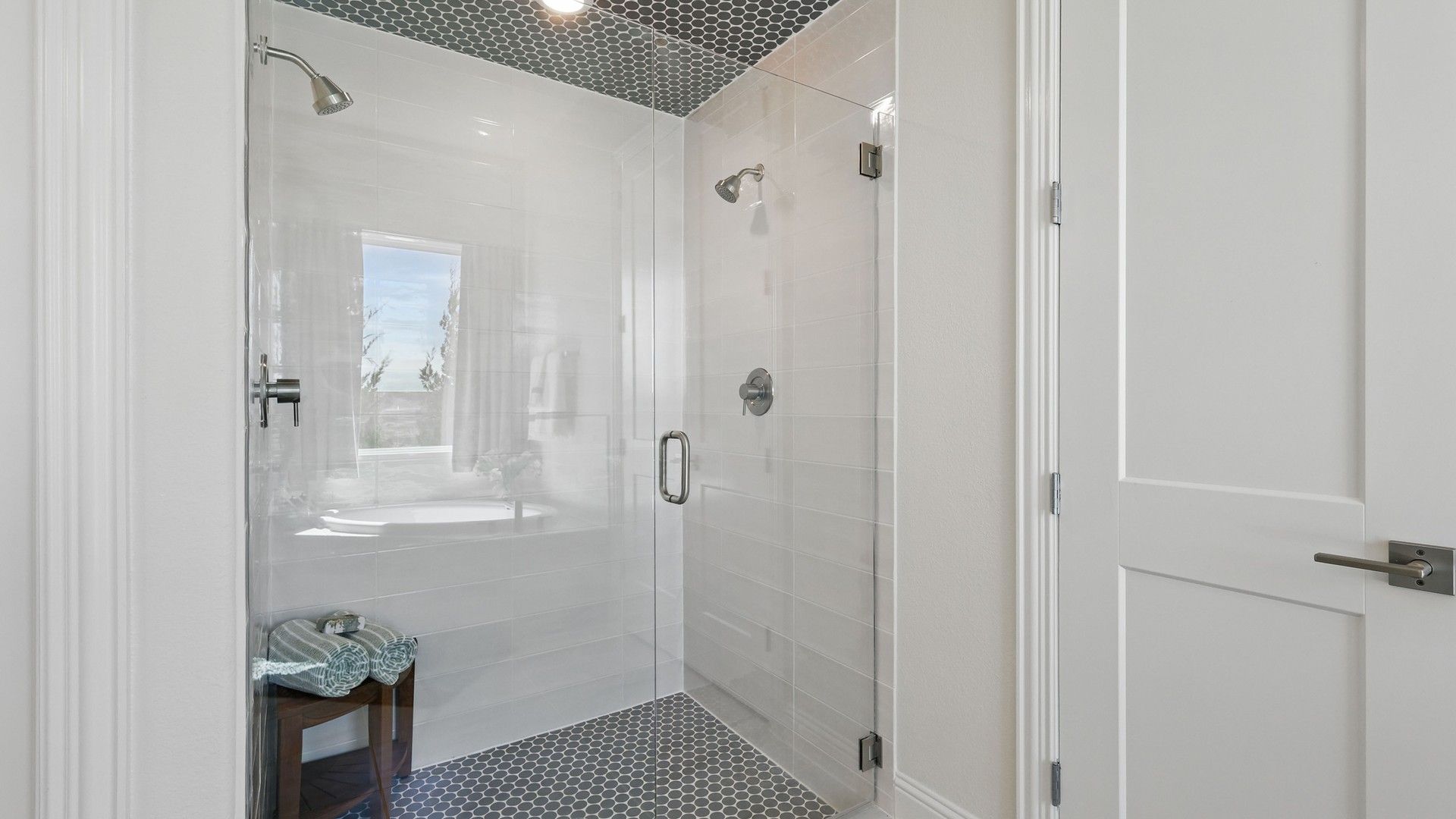 Sophisticated shower with hexagonal tiles and premium fixtures in Kelly Ranch’s Rio Vista enclave.
