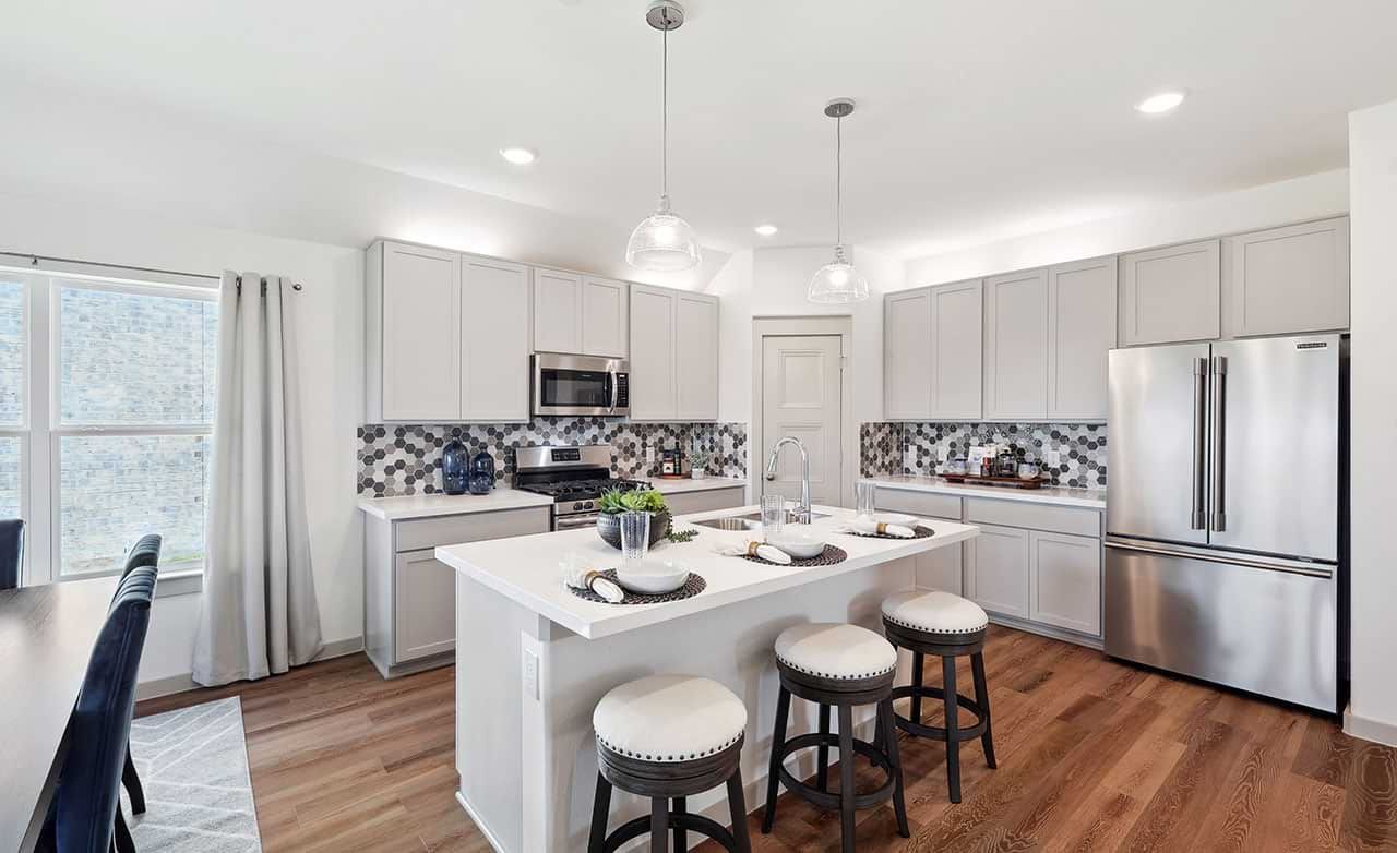 Elegant kitchen with hexagon tile backsplash and sleek island. Walden Pond location.
