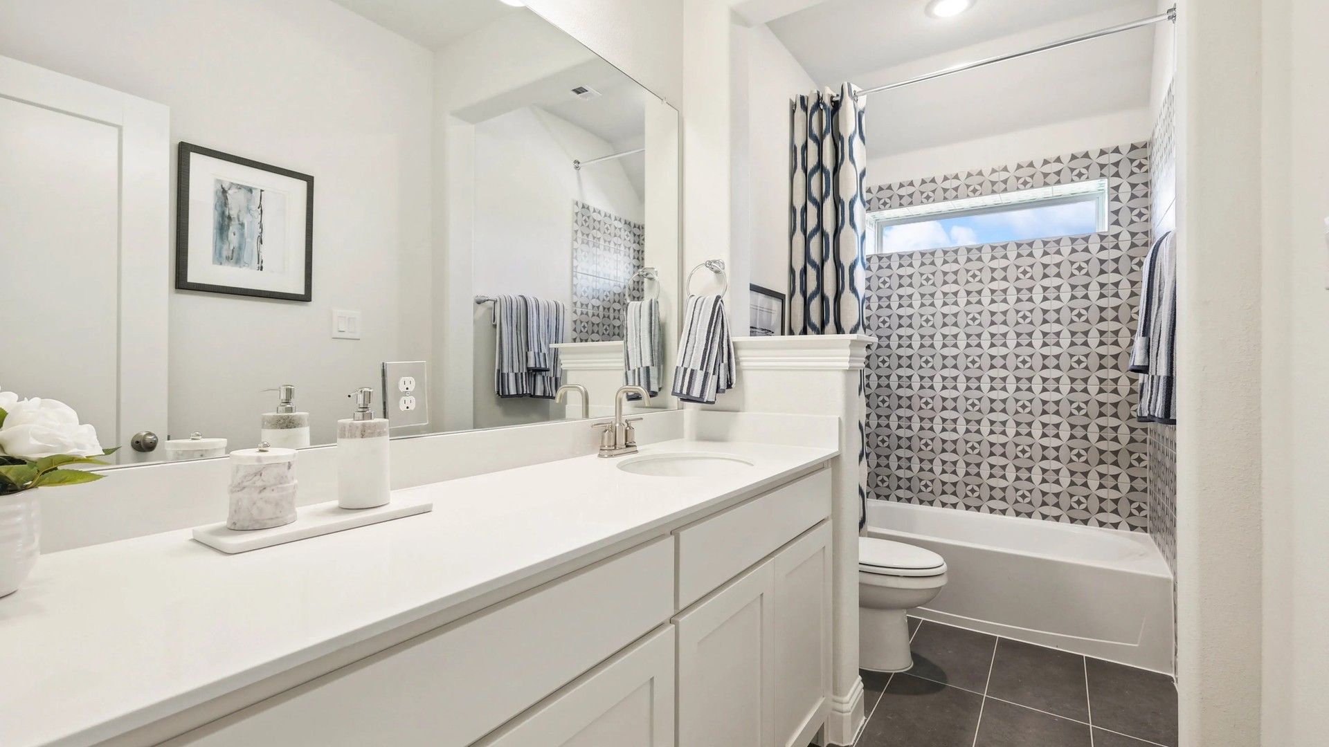 Luxurious bathroom features striking geometric tile and sleek fixtures in Ridge Crossing.
