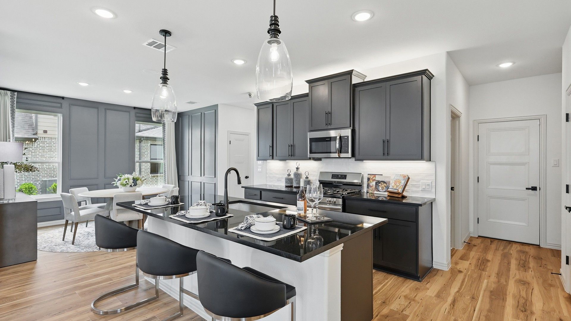 Luxurious Westridge kitchen featuring sleek black cabinetry, gourmet island, and polished wood flooring.