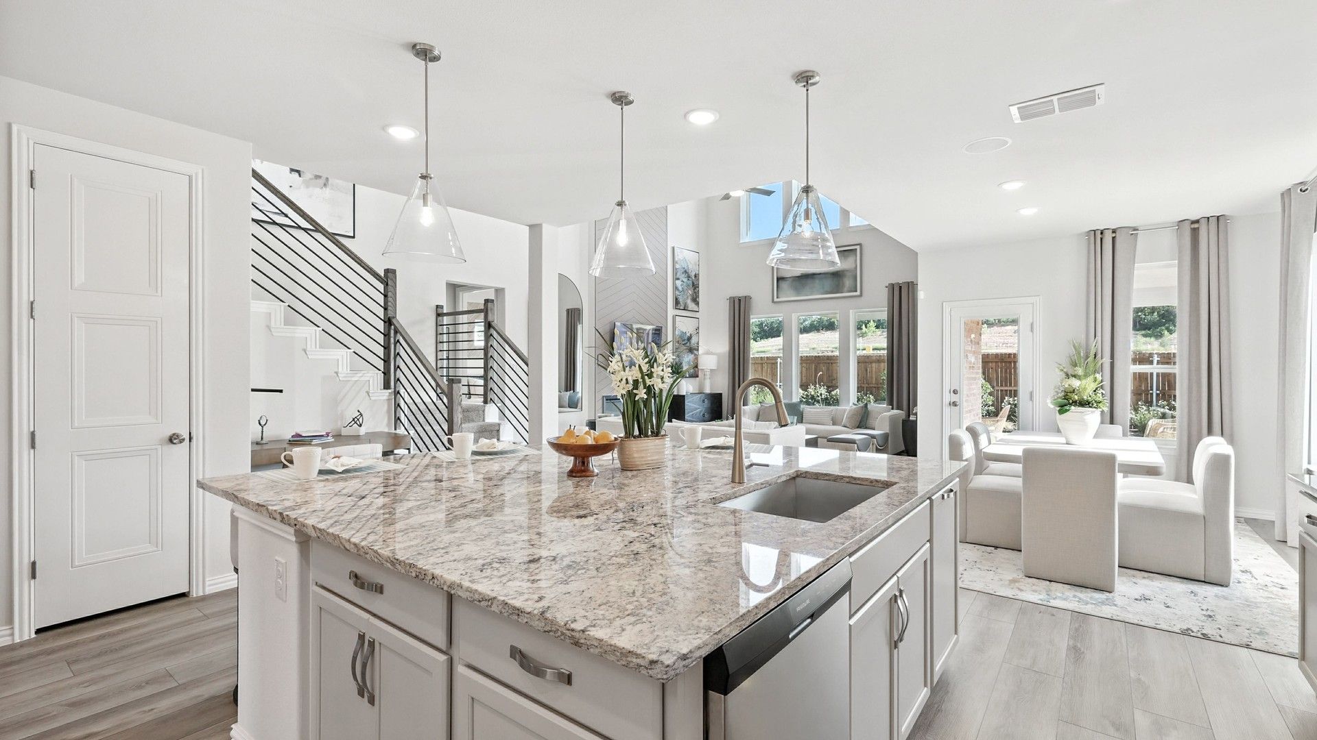 Granite countertops, sleek lighting, and airy space define this Green Oaks Preserve home's sophisticated kitchen.