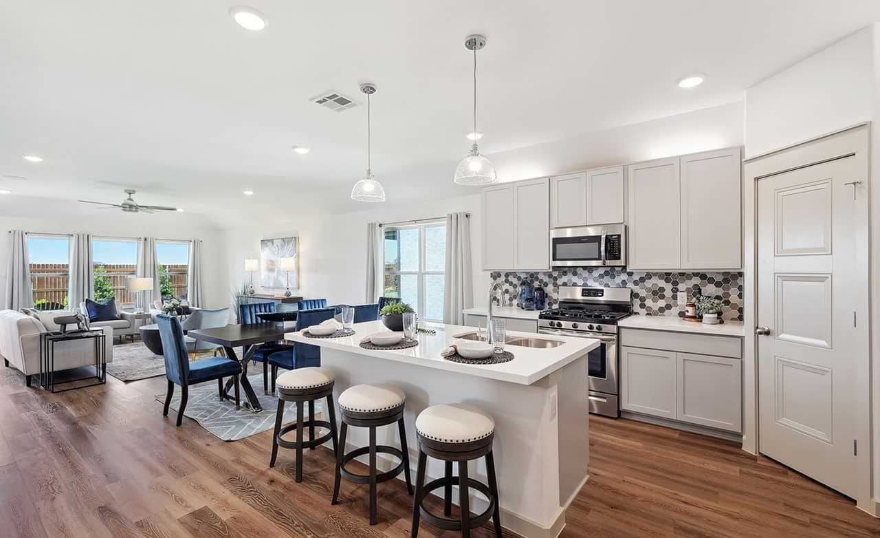 Chic Walden Pond kitchen with hexagonal backsplash, sleek island, and expansive windows offering natural light.