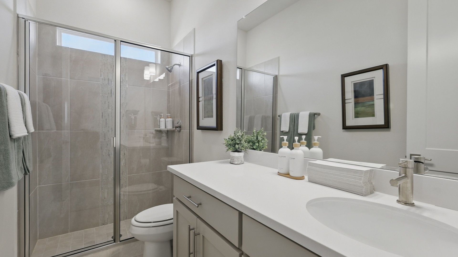Luxuriously designed with a pristine white vanity and sleek glass shower at Rio Vista, Kelly Ranch.