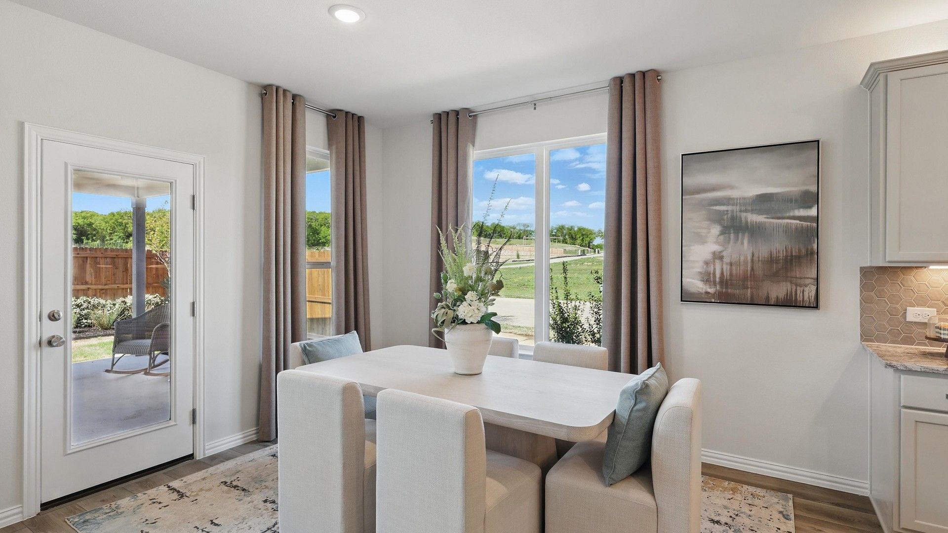 Sleek dining space with plush seating, artful accents, and abundant natural light in Green Oaks Preserve.