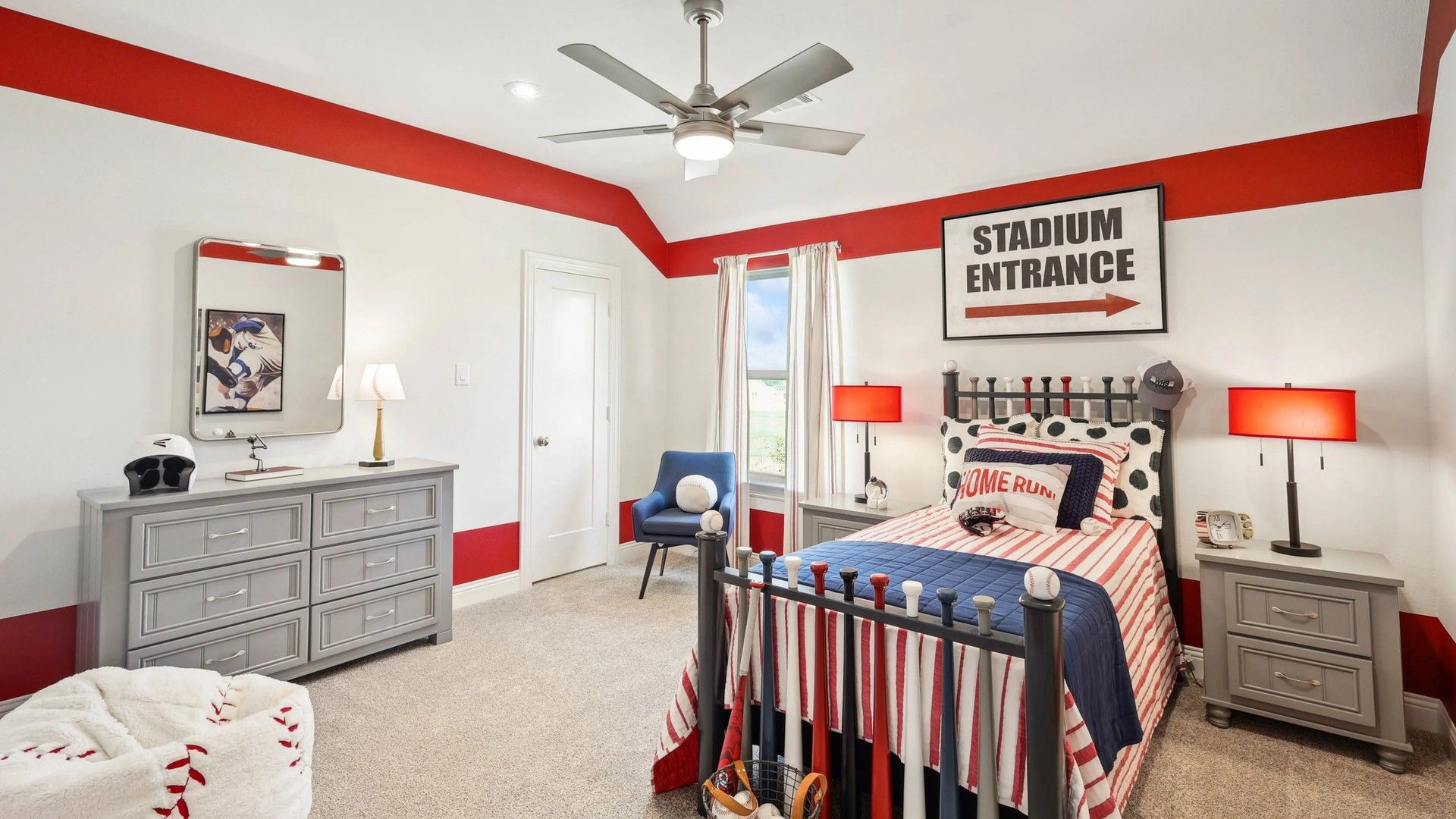 Sports-inspired bedroom with bold red decor and sleek furnishings in Ridge Crossing community.