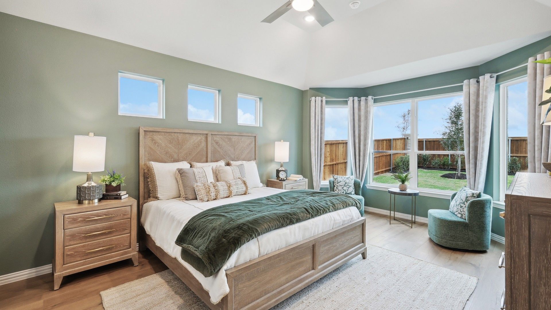 Luxurious bedroom features vaulted ceiling, expansive windows, and chic wood finishes in Wildflower Ranch.