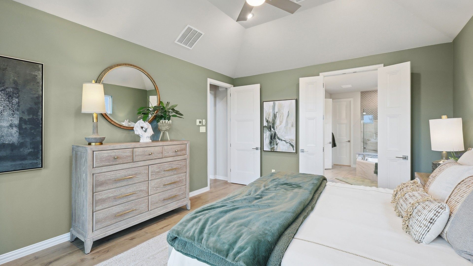 Indulge in premium comfort at Wildflower Ranch. Vaulted ceilings and luxe decor enhance this serene bedroom retreat.
