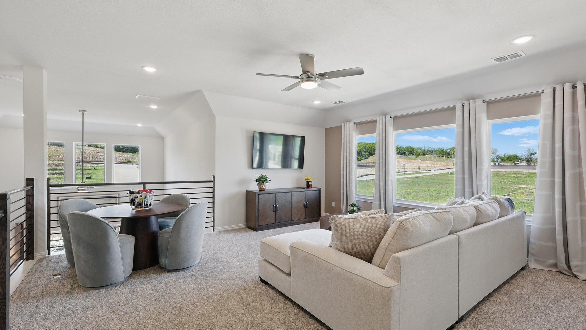 Sophisticated seating area with expansive windows, plush carpeting in Green Oaks Preserve community.