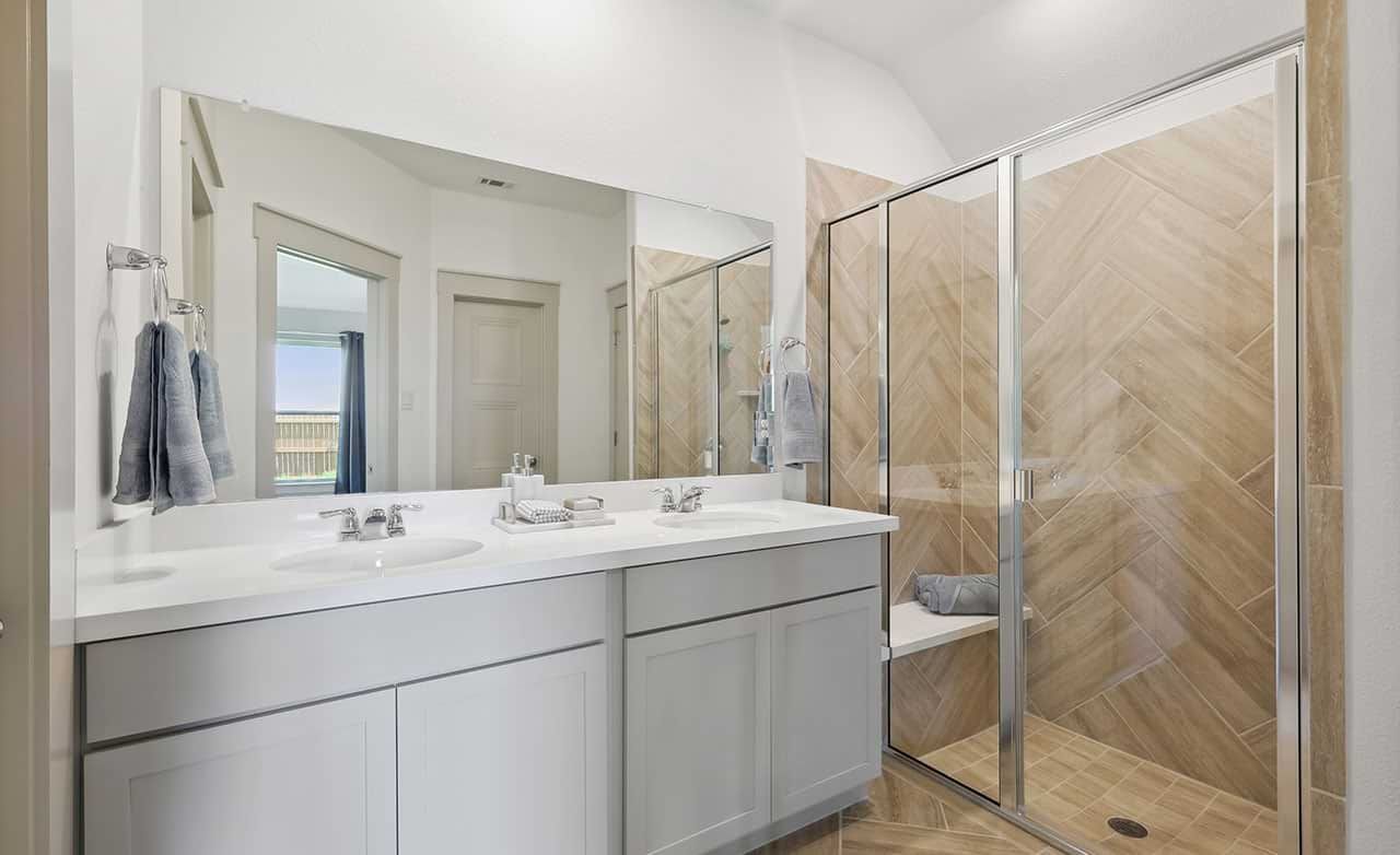 Discover luxury with sleek double vanity and herringbone-tiled shower in Walden Pond.