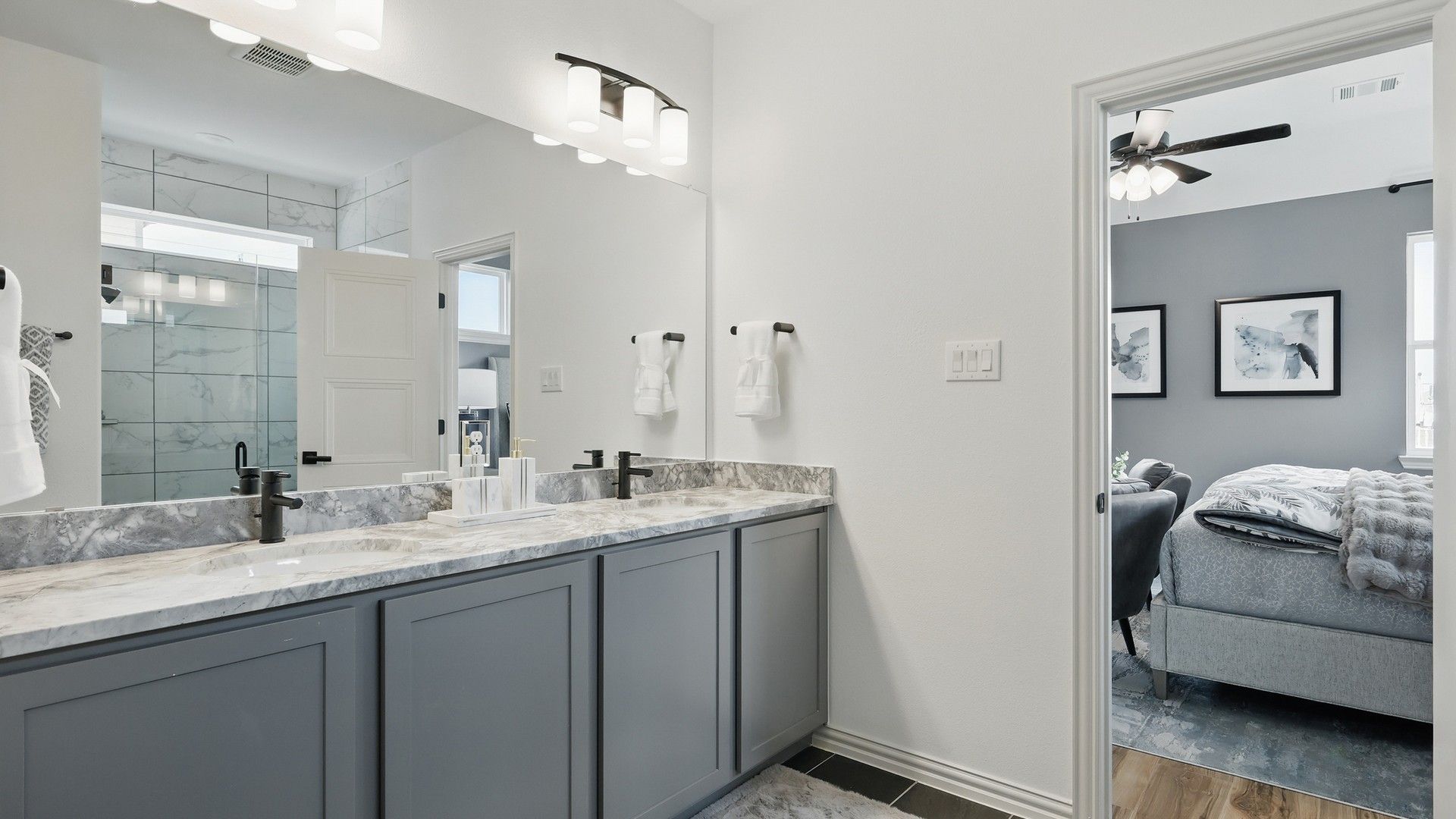 Luxurious Westridge bath features marble vanity, modern black fixtures, and a glass shower.