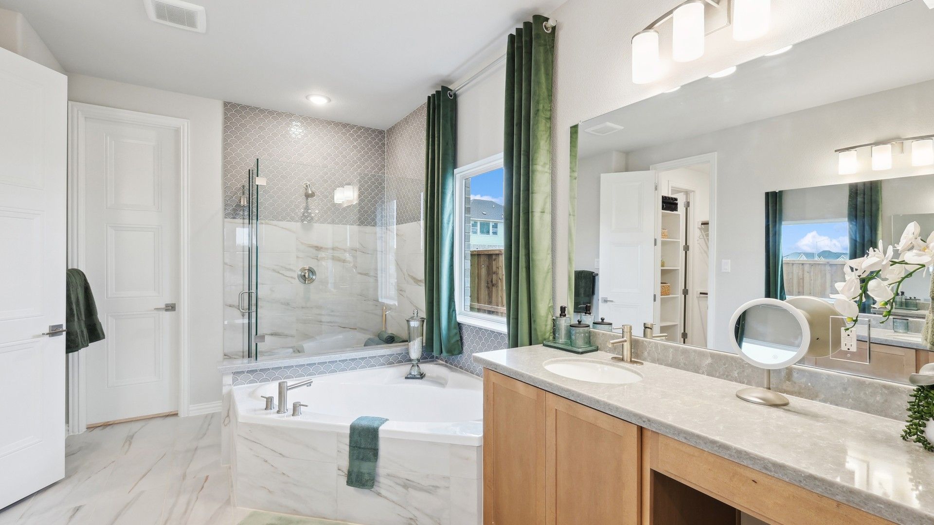 Indulge in marble elegance; dual vanity and soaking tub evoke refinement at Wildflower Ranch.