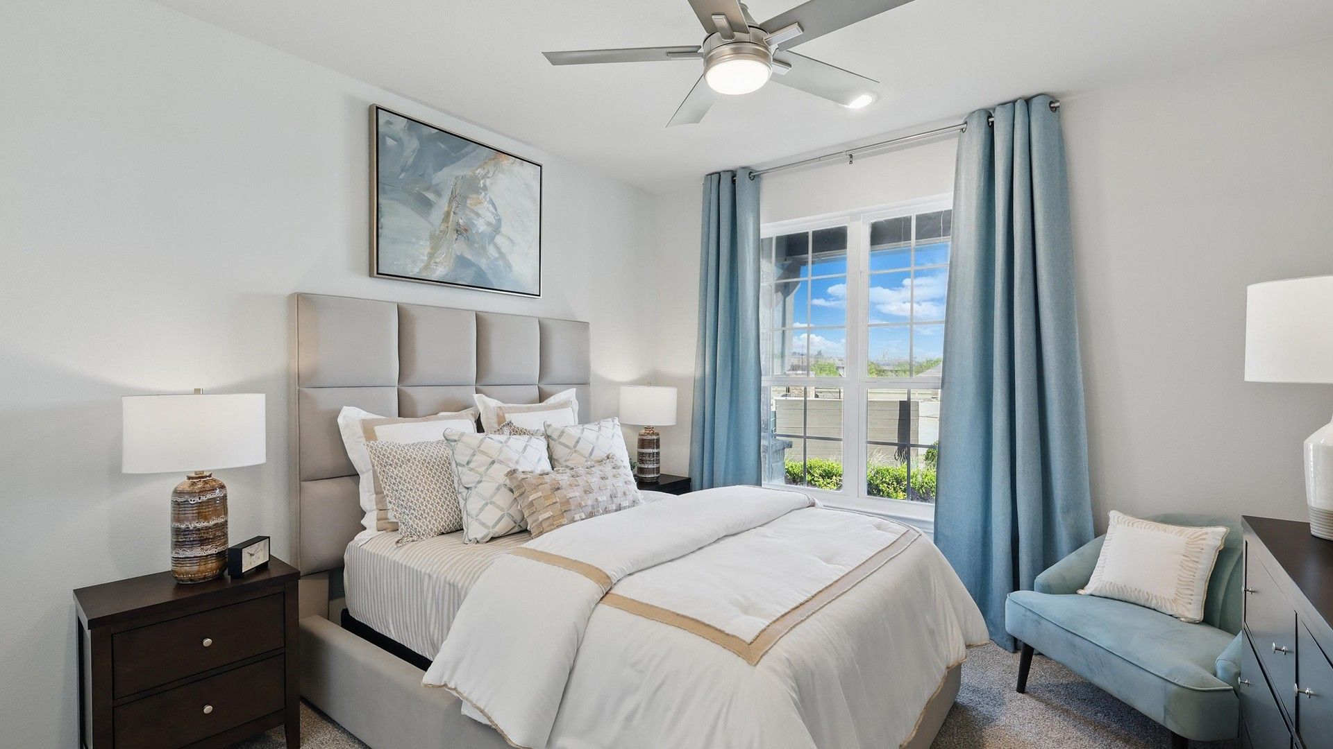 Experience plush comfort with exquisite details like a tufted headboard and serene garden views in Green Oaks Preserve.