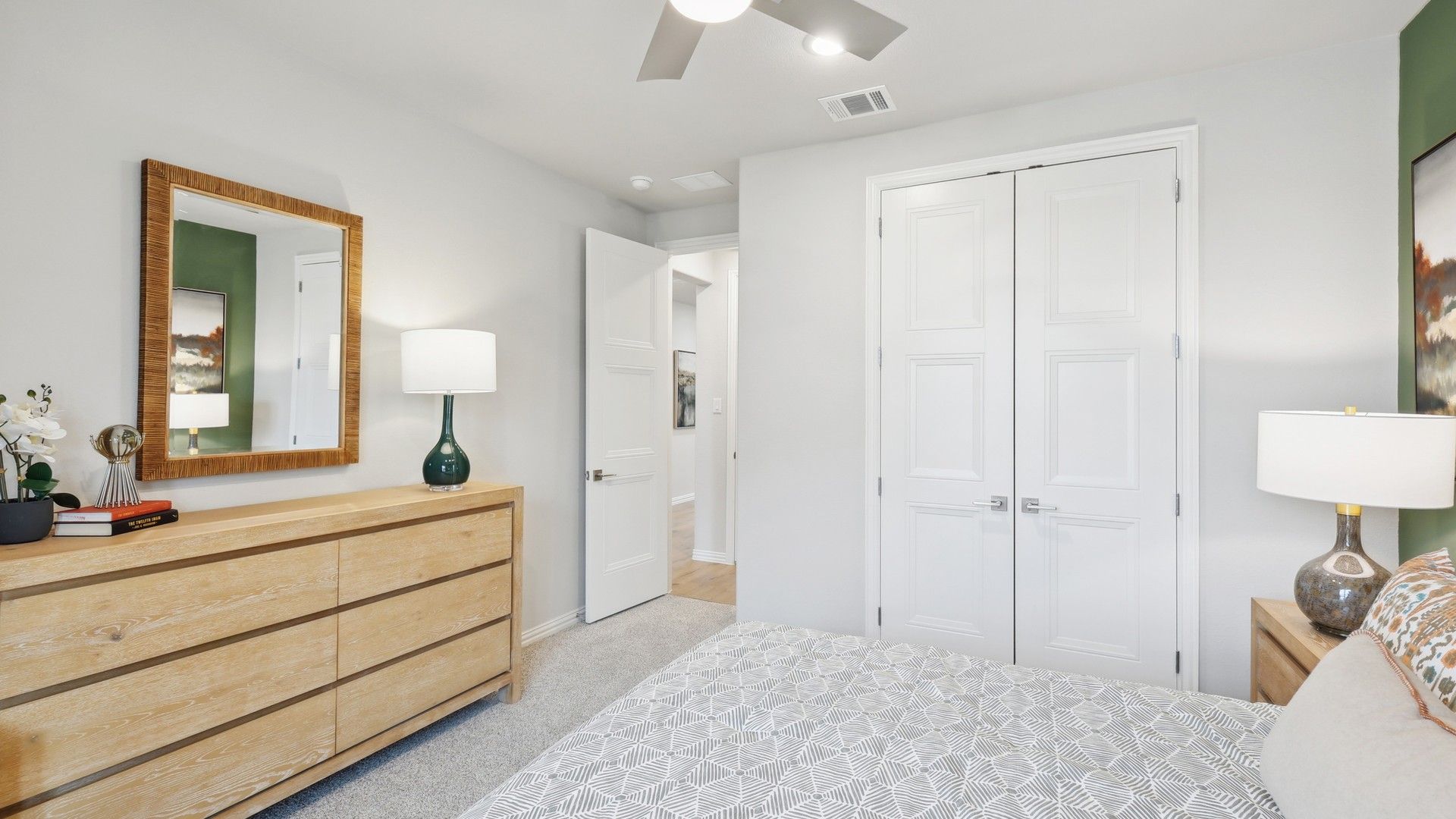 Luxurious bedroom in Wildflower Ranch boasts a sleek wood dresser and stylish ceiling fan, exuding modern elegance.