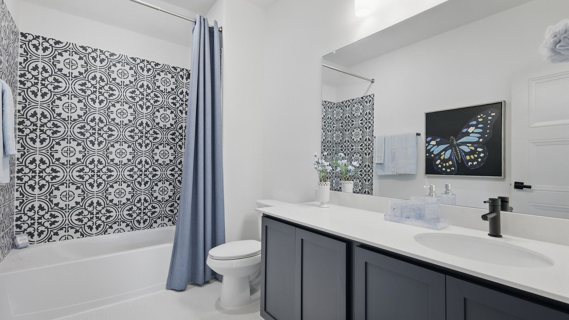 Luxurious bathroom with black vanity, striking patterned tiles, and refined blue accents in Westridge.