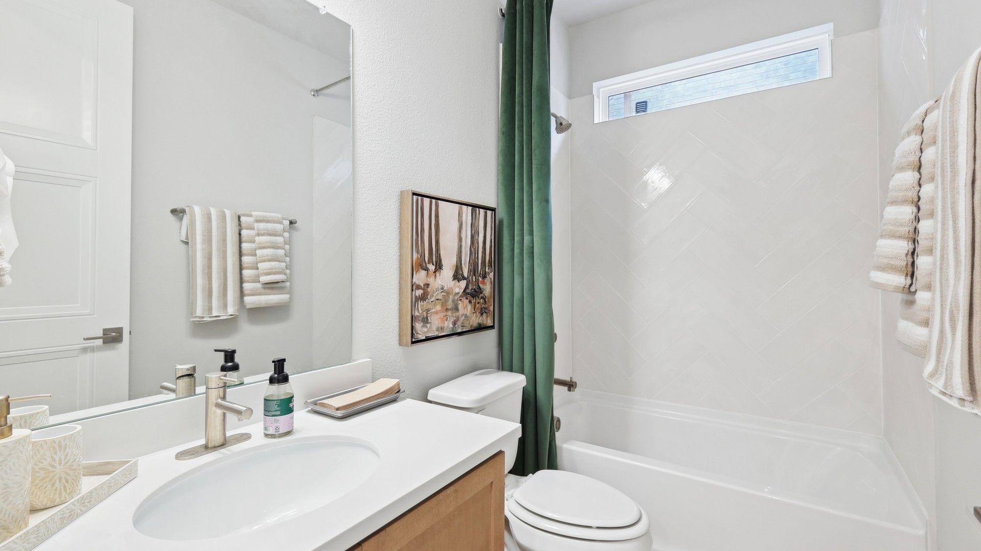 Experience luxury with herringbone tiles and sleek vanity in Wildflower Ranch. Indulge in top-tier design.