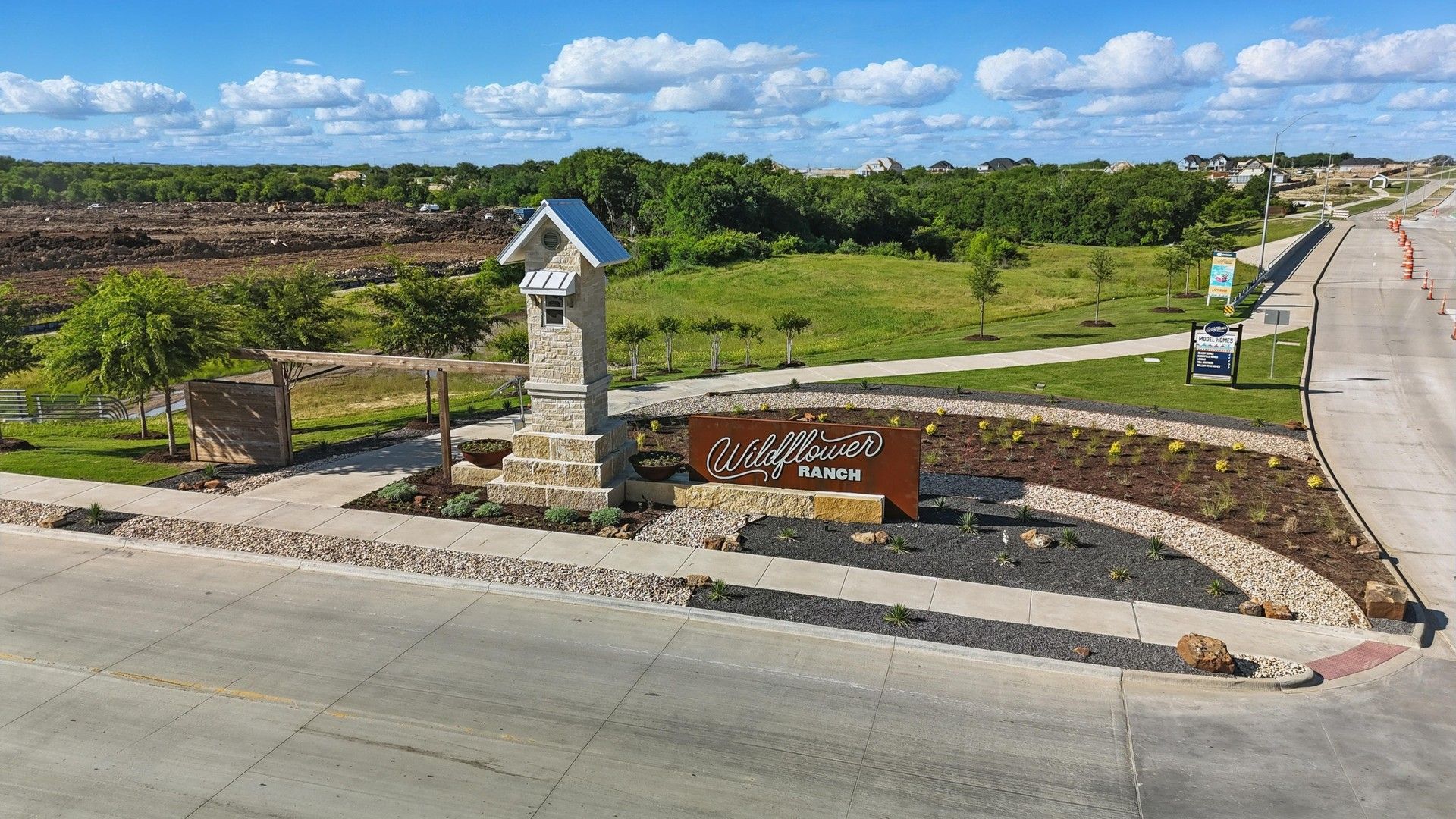 Elegant stone pillar and manicured landscaping welcome you to Wildflower Ranch, Fort Worth.