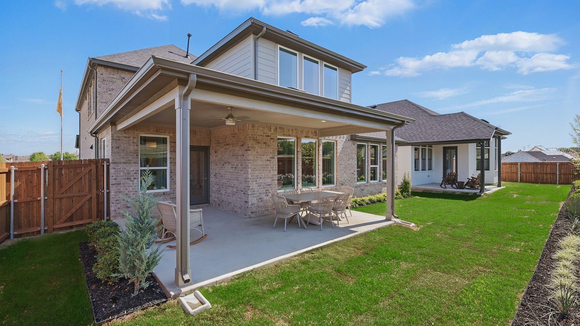 Elegant brick exterior and spacious patio enhance luxury in Green Oaks Preserve.
