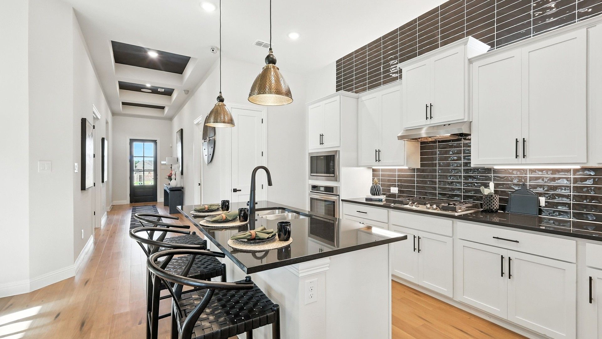 Elegant white cabinetry and black granite countertops exemplify sophistication in Green Oaks Preserve.