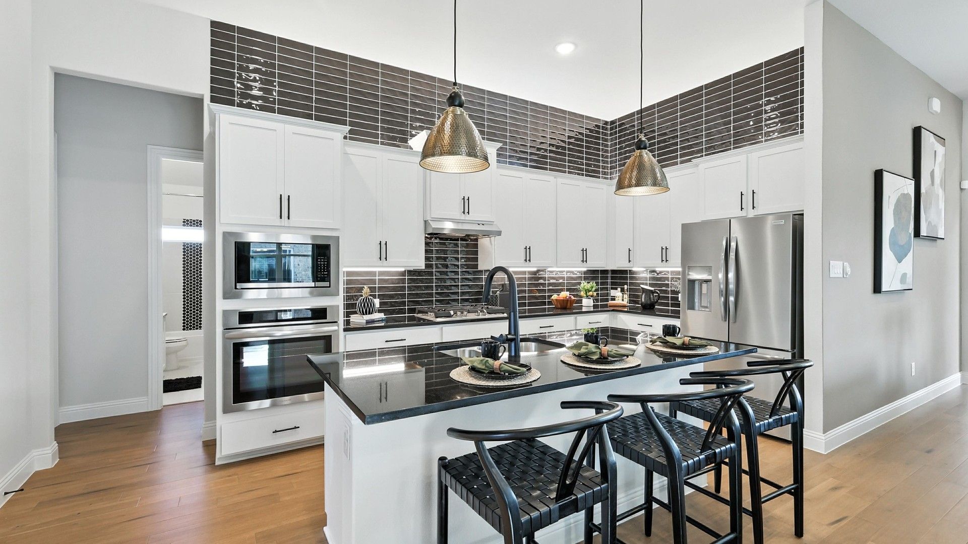 Elegant kitchen features sleek black countertops and pendant lighting. Located in prestigious Green Oaks Preserve.